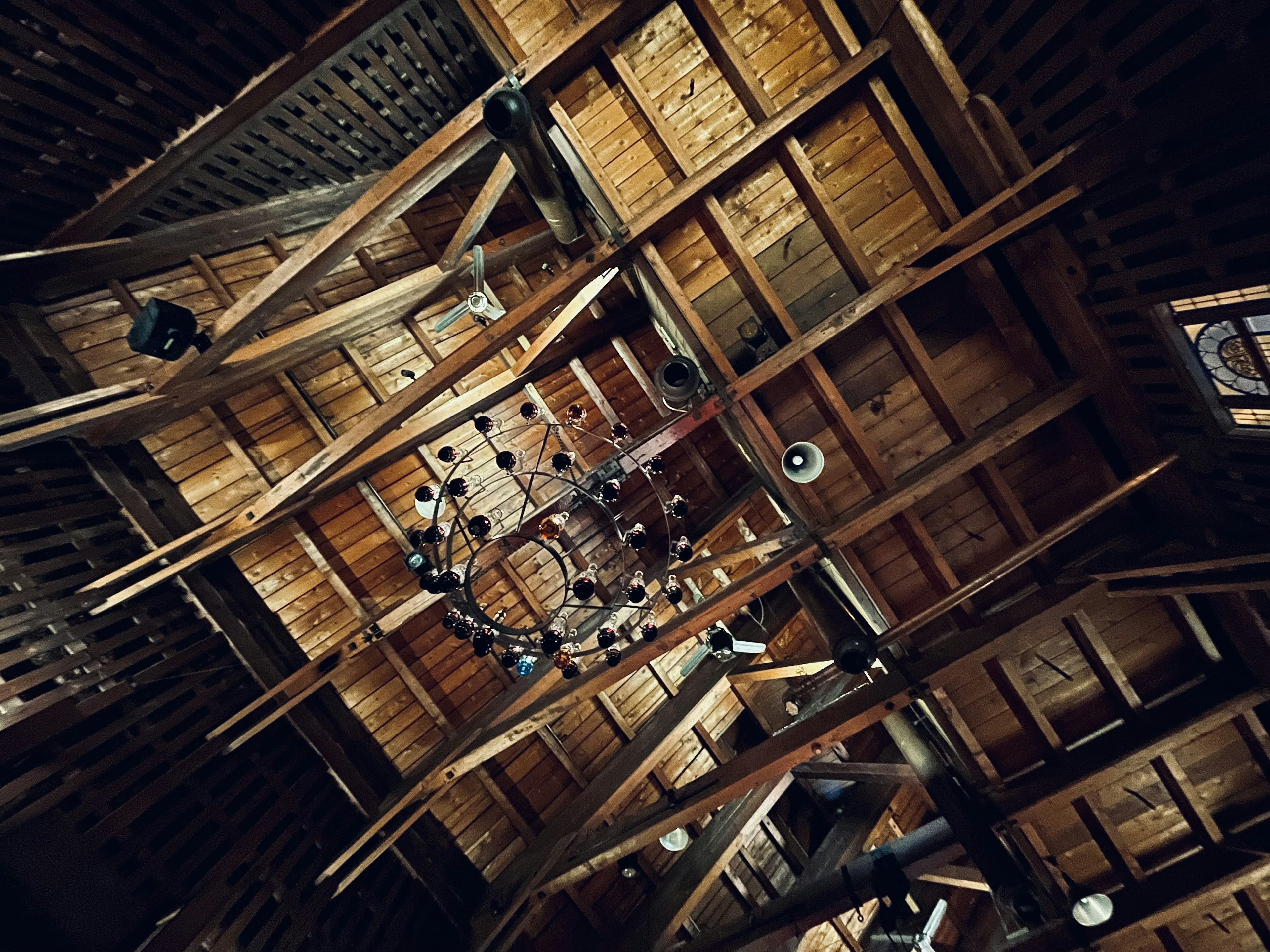 Interior view of a wooden ceiling with beams and a chandelier