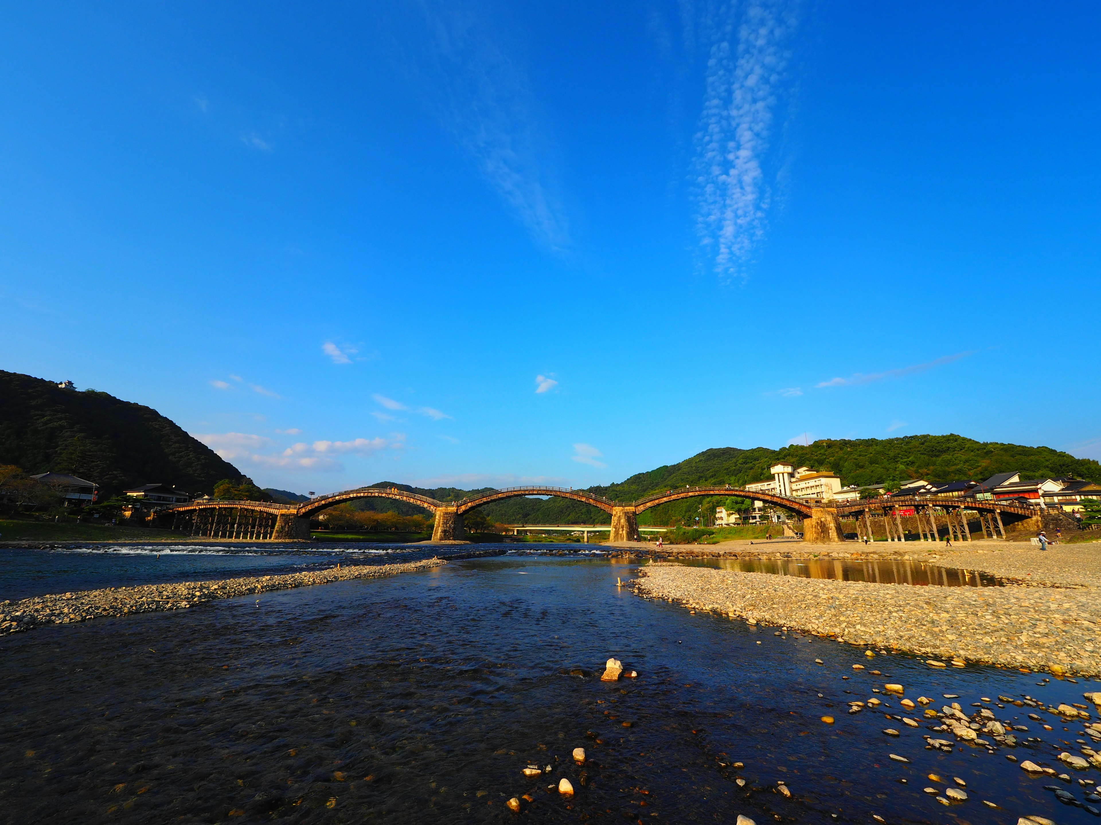 Vista panoramica di un fiume con un ponte sotto un cielo blu