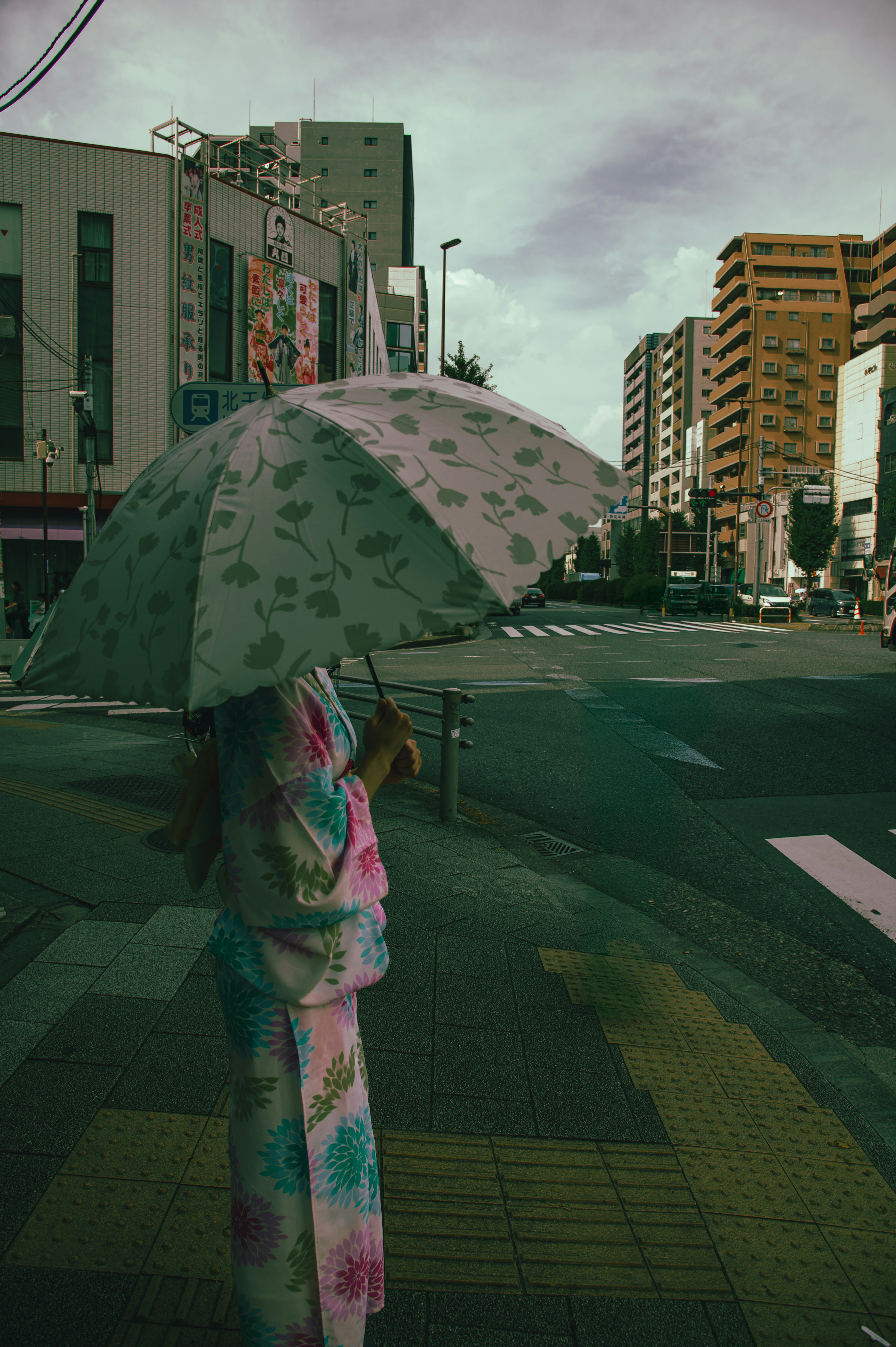 Eine Frau in einem bunten Kimono mit einem Regenschirm in einer städtischen Szene