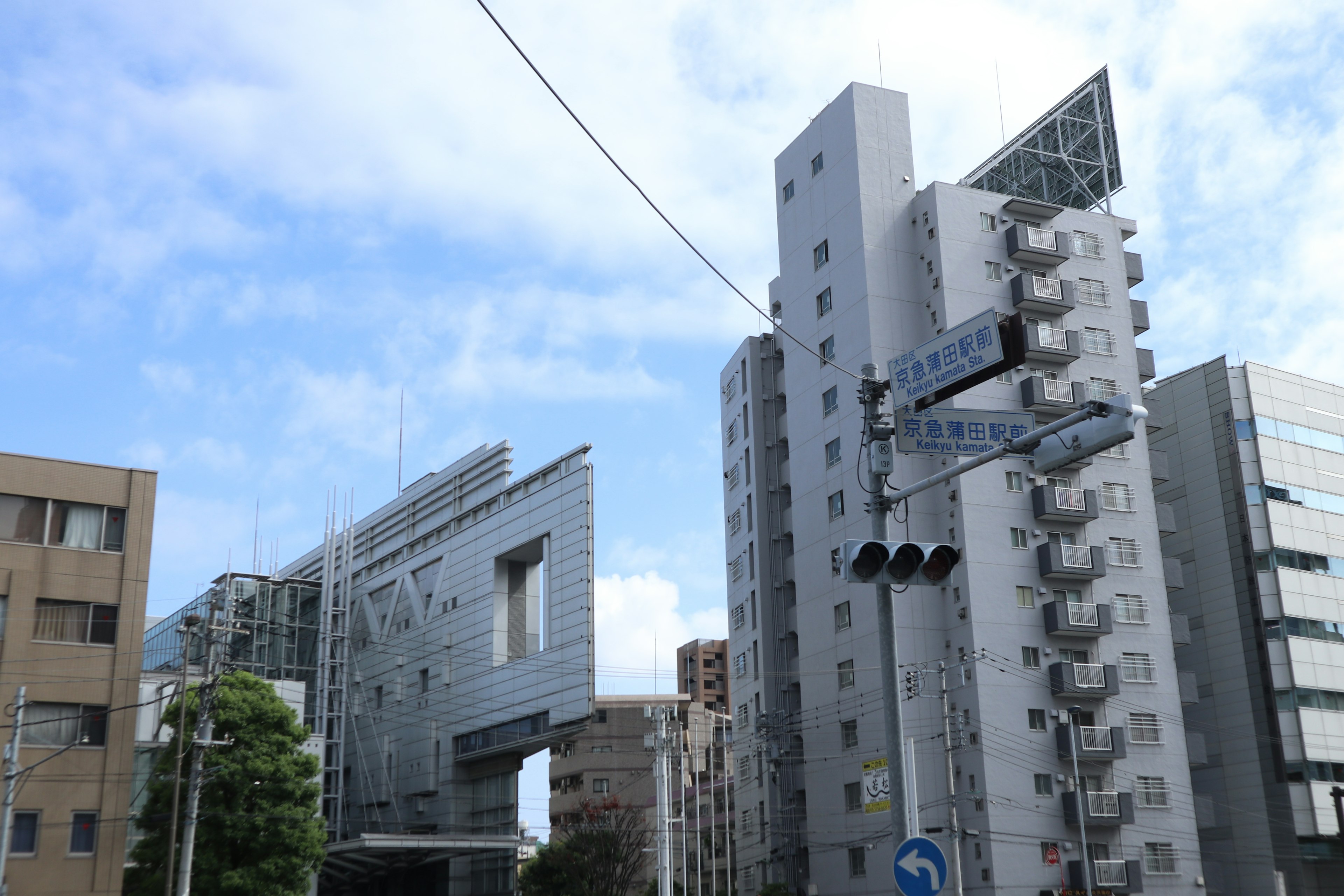 Urban landscape featuring modern buildings under a blue sky with clouds