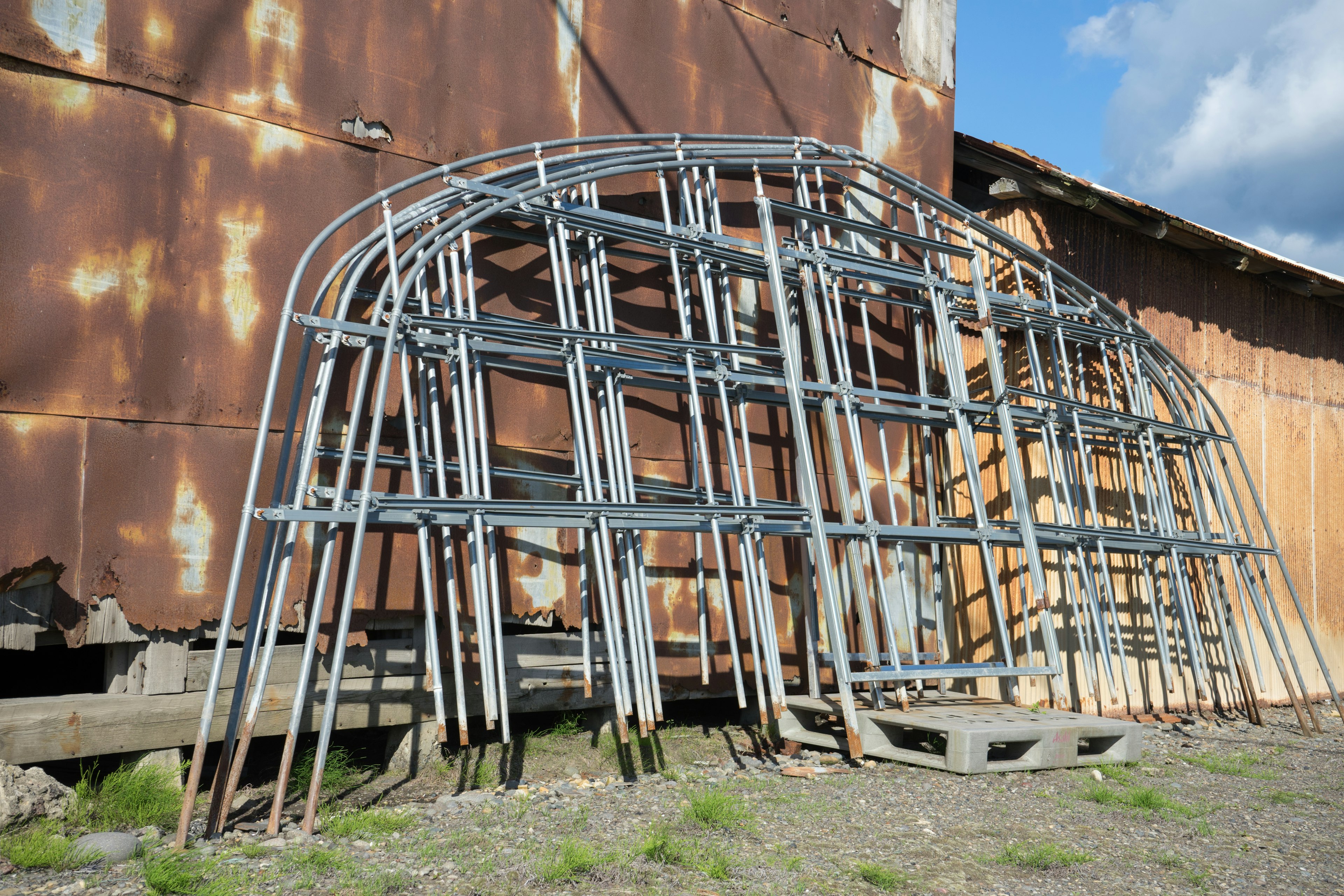 Estructura de metal apoyada contra una pared vieja