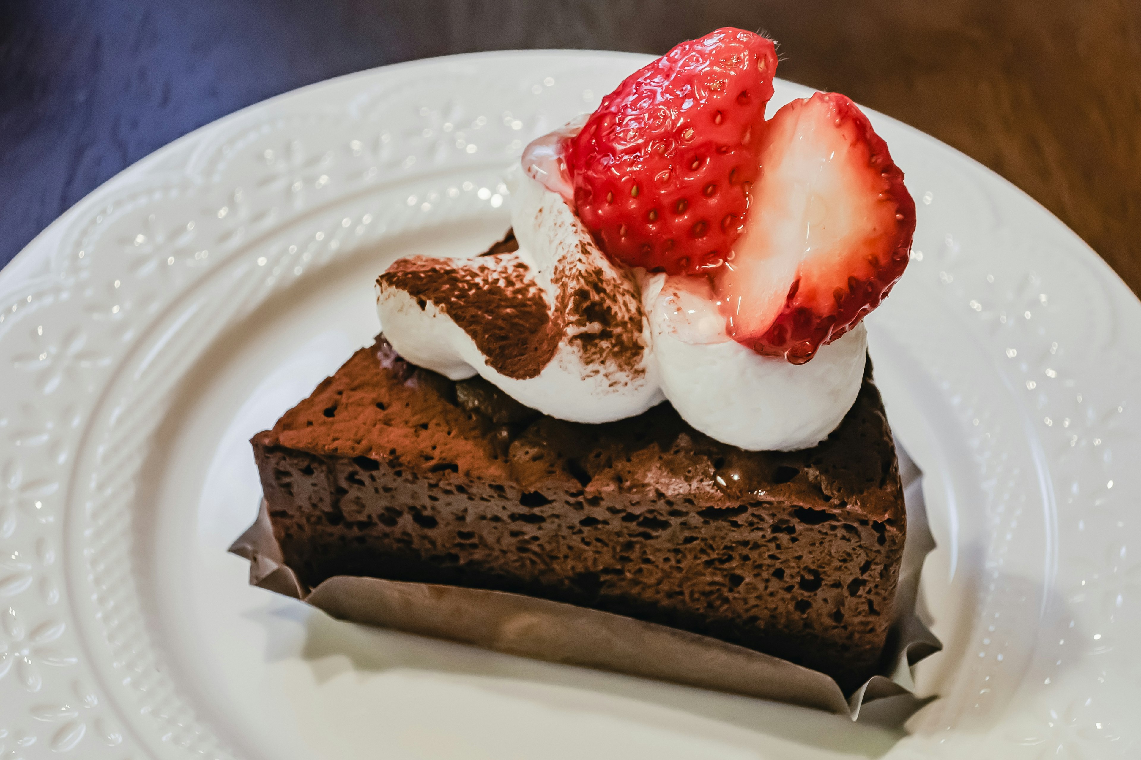 Pastel de chocolate cubierto con crema batida y fresas