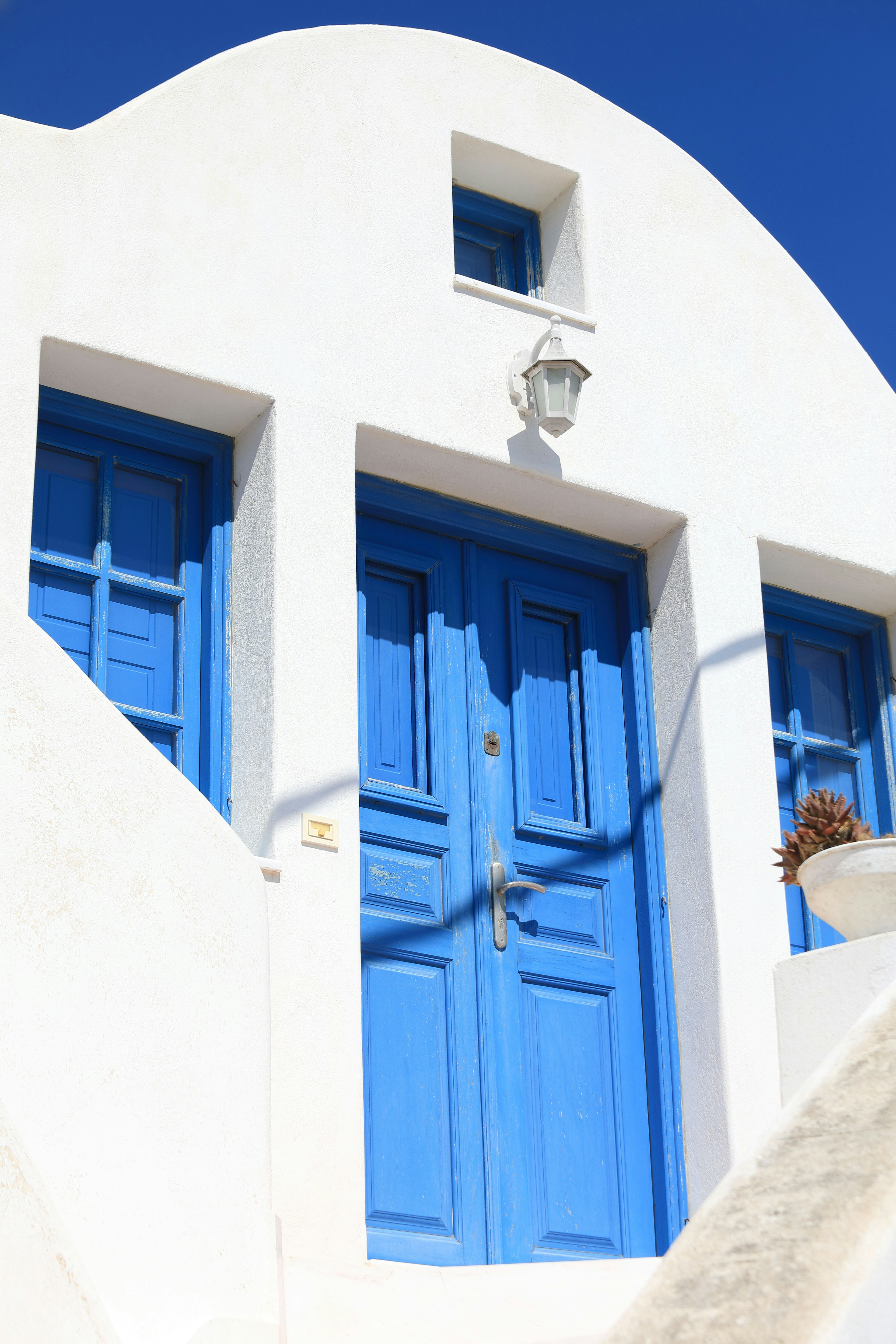 Edificio blanco con puertas y ventanas azules llamativas