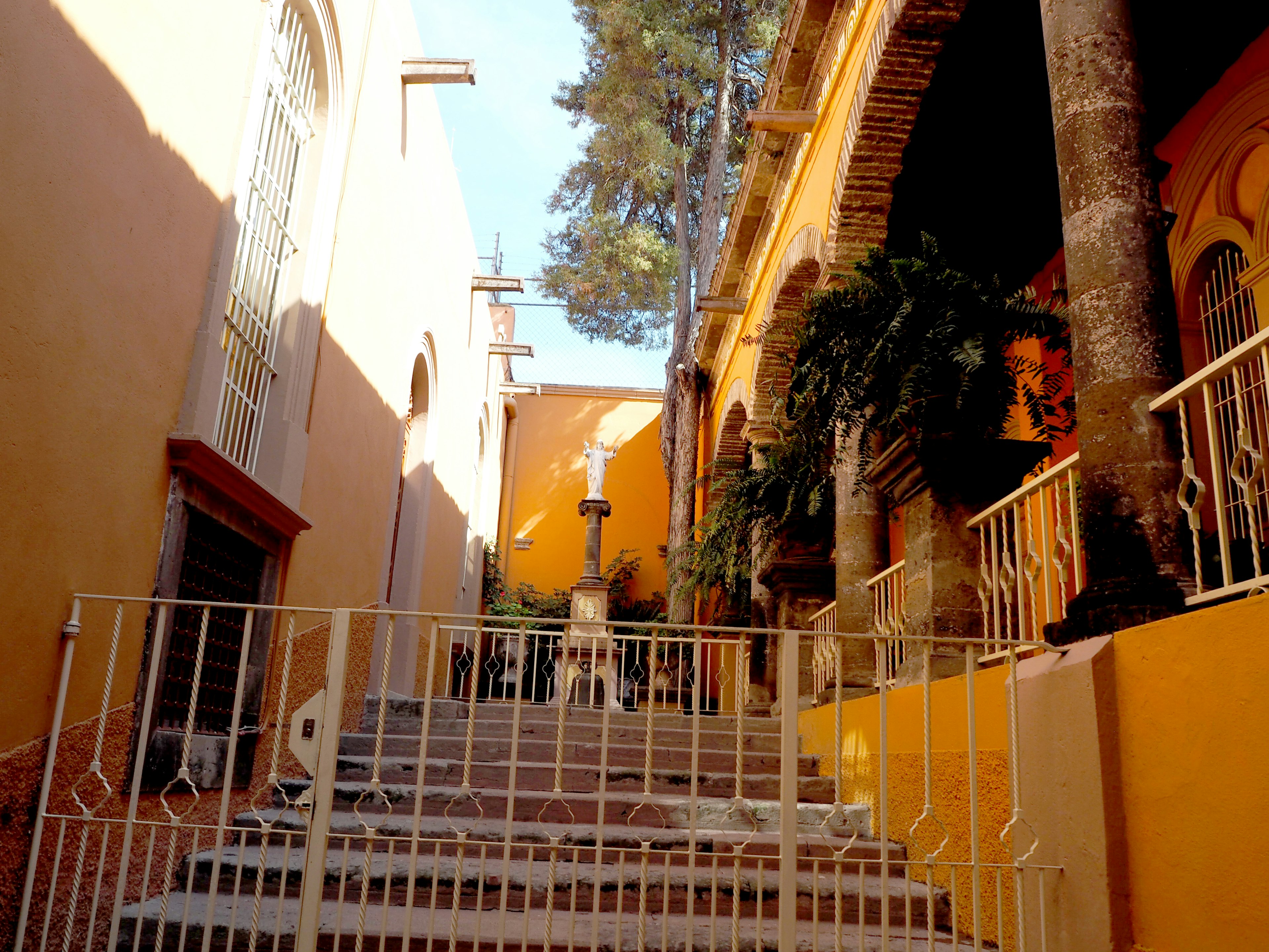 Calle tranquila con escaleras rodeadas de muros naranjas