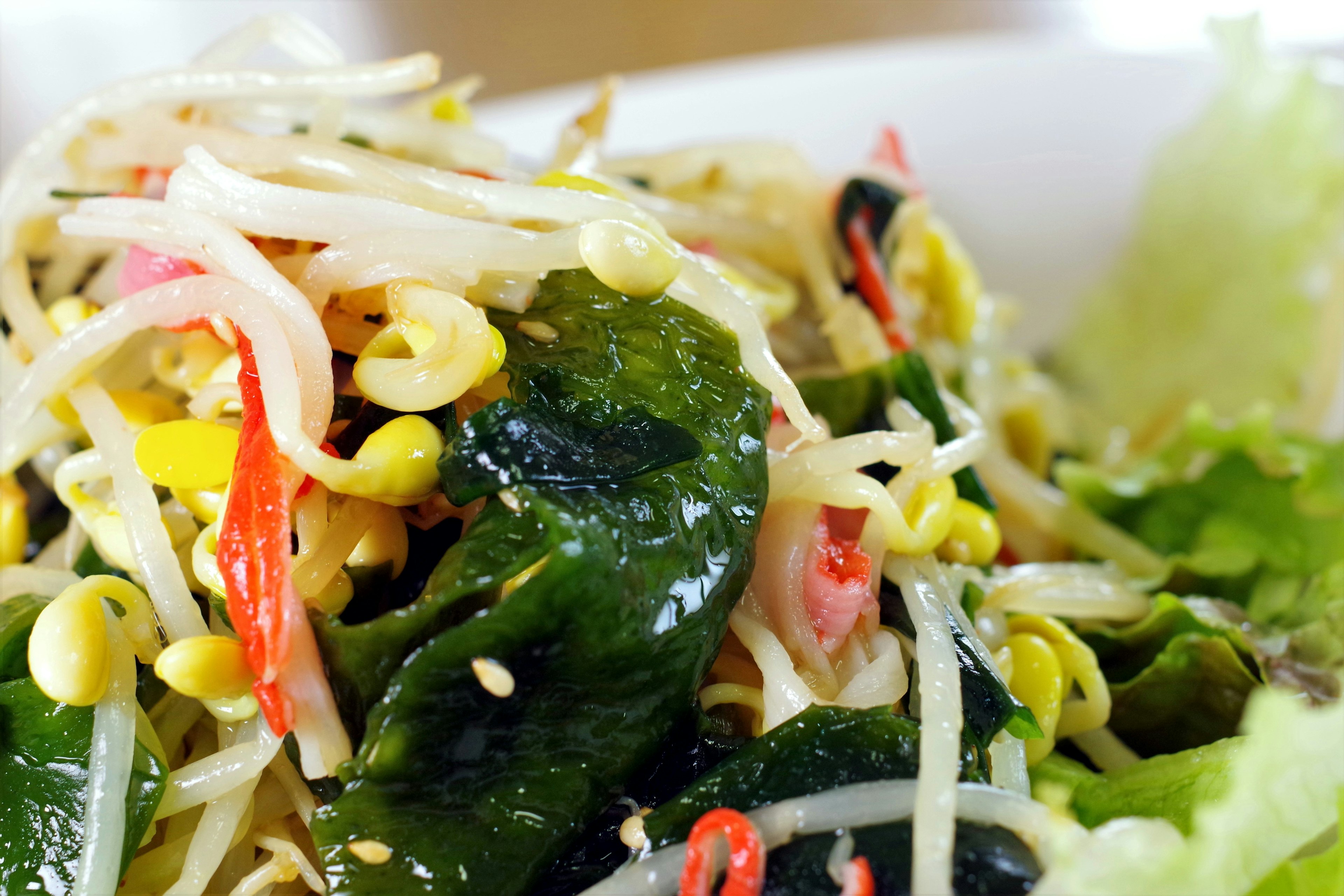 Colorful salad with vegetables and seaweed featuring fresh bean sprouts and chili peppers