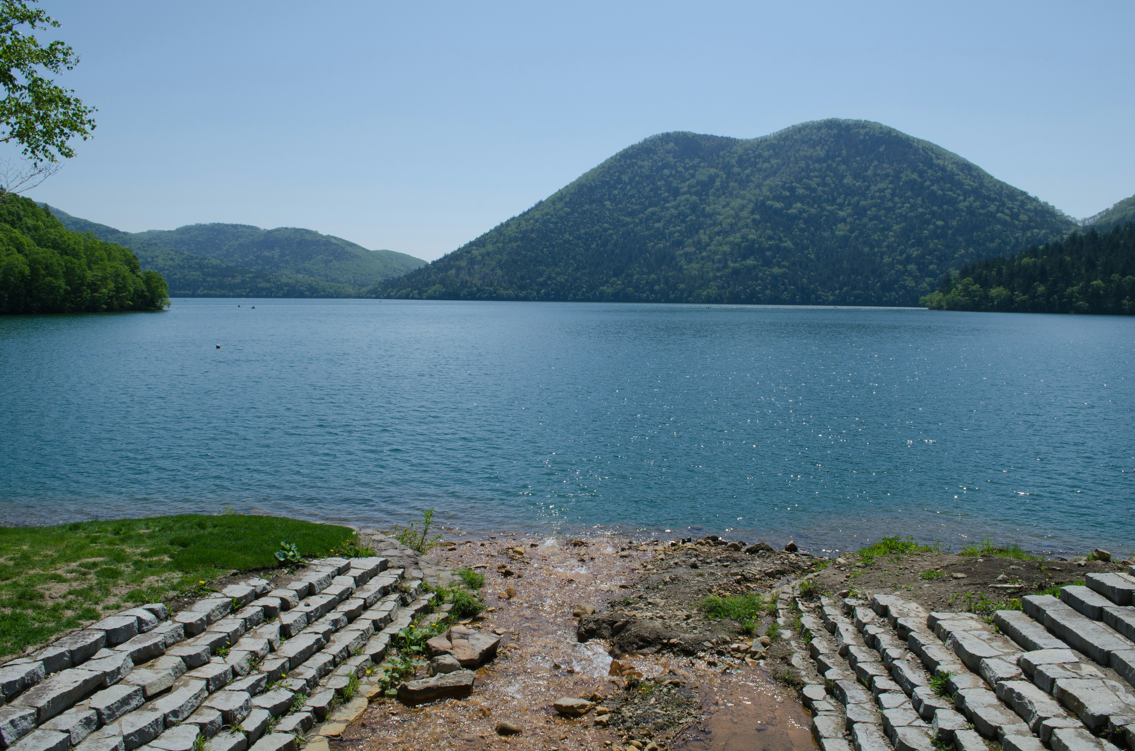 宁静湖泊的风景，四周环绕着山脉，水面清澈