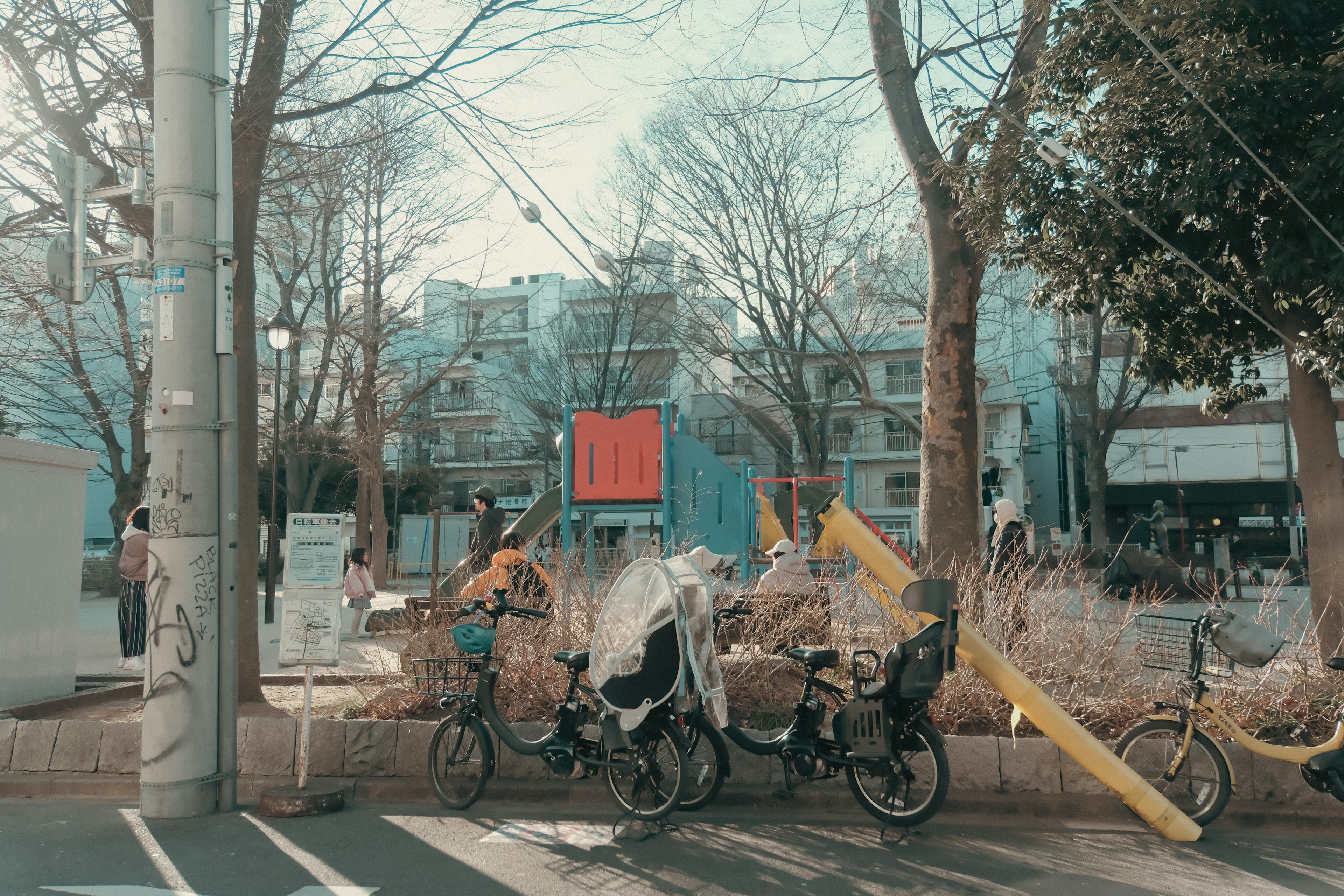 青い建物と自転車が並ぶ公園の風景