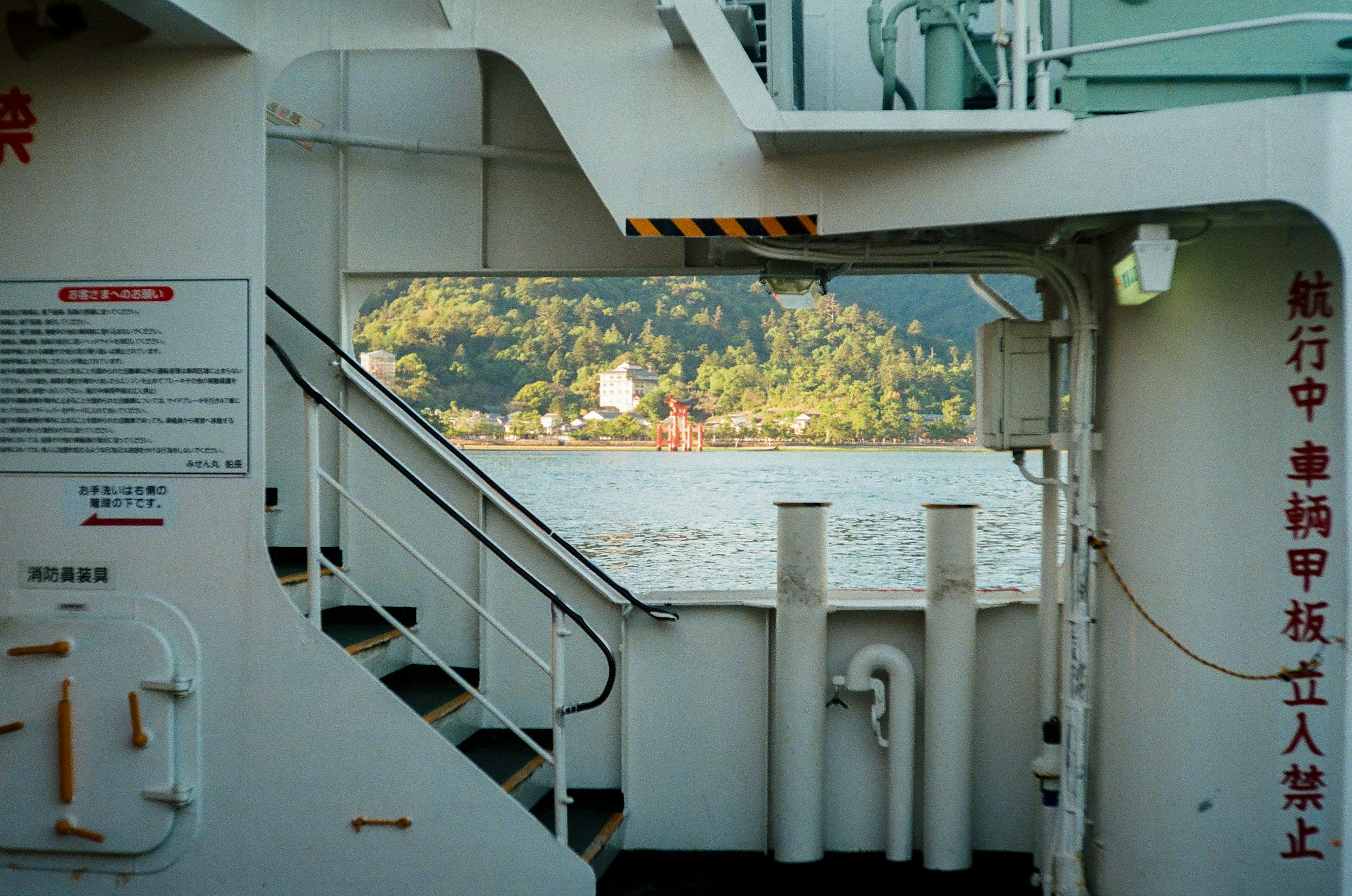 View from inside a ship showing stairs and a scenic landscape