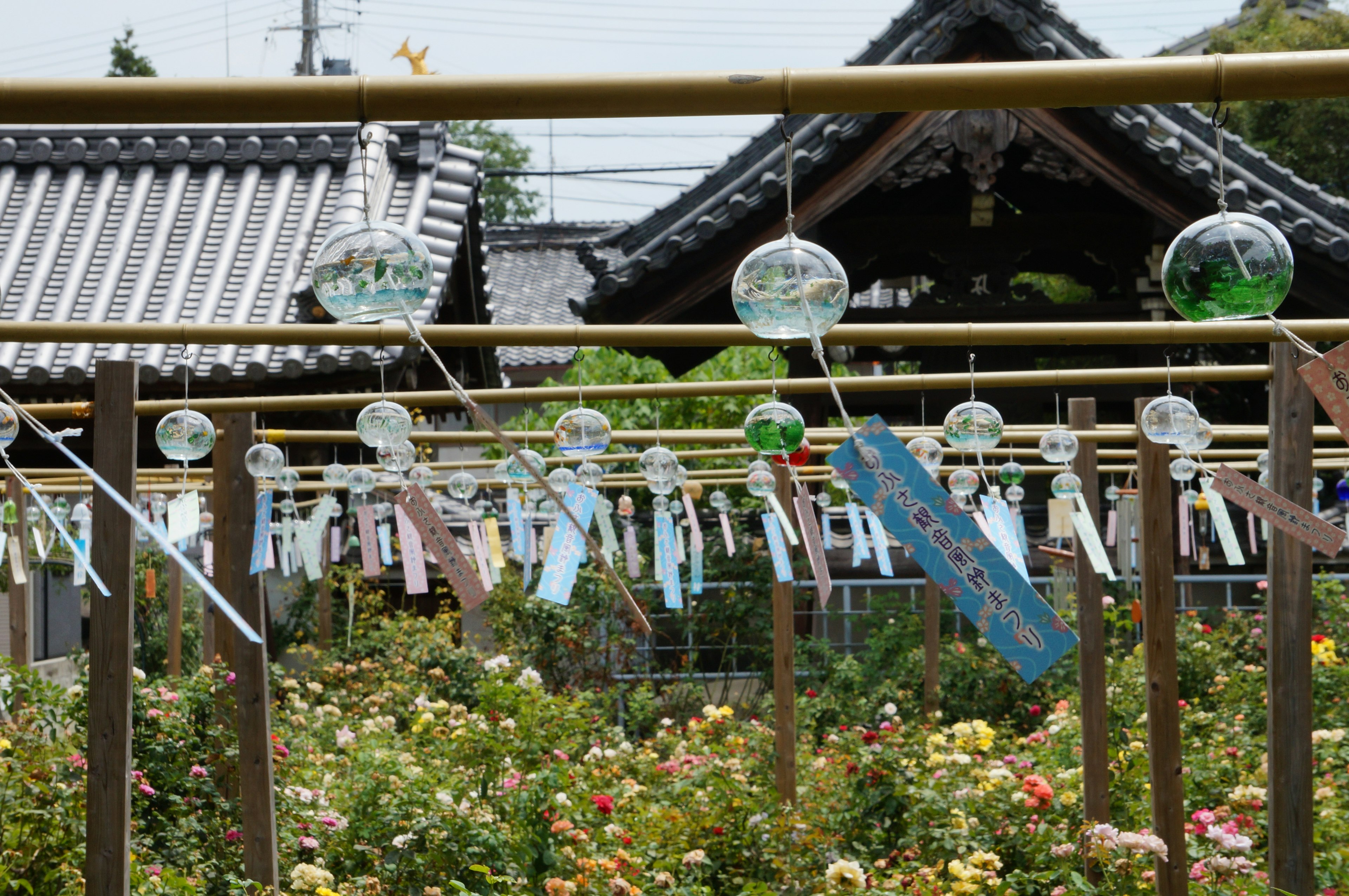 Jardin japonais avec des carillons éoliens suspendus à du bambou et des bandes de papier colorées