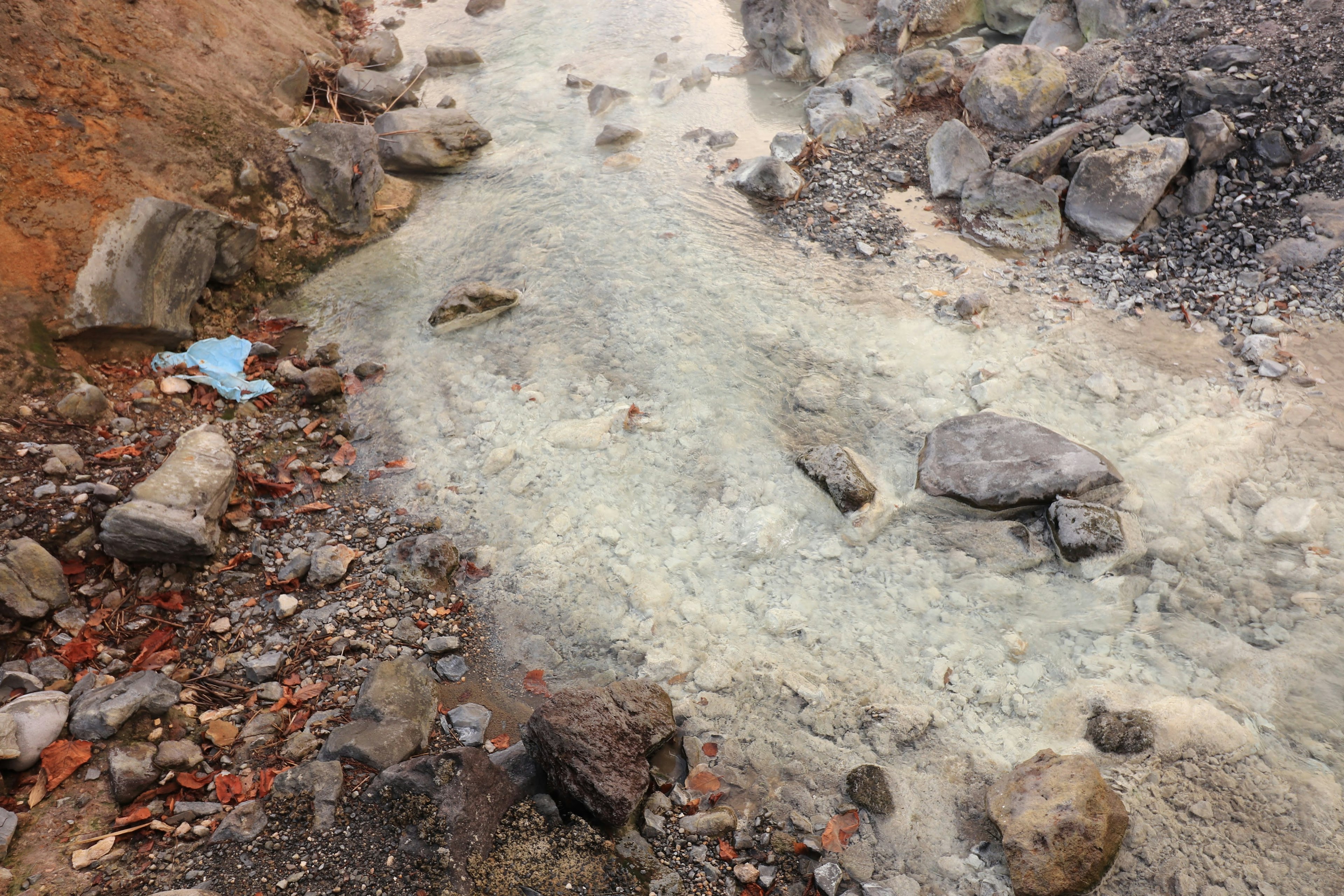 Cauce de arroyo seco con piedras dispersas y suelo claro