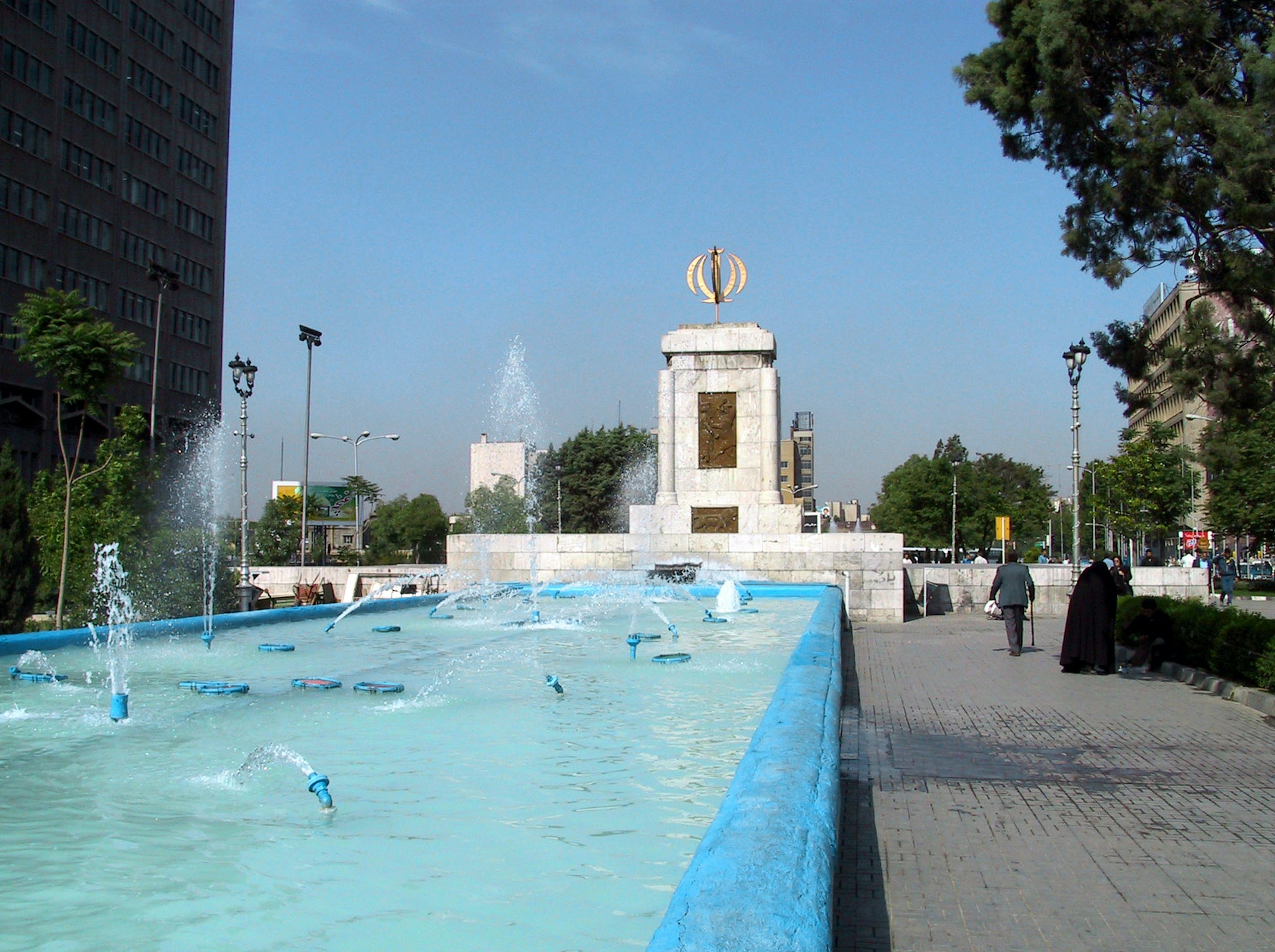 Scène de parc avec une fontaine bleue et un monument