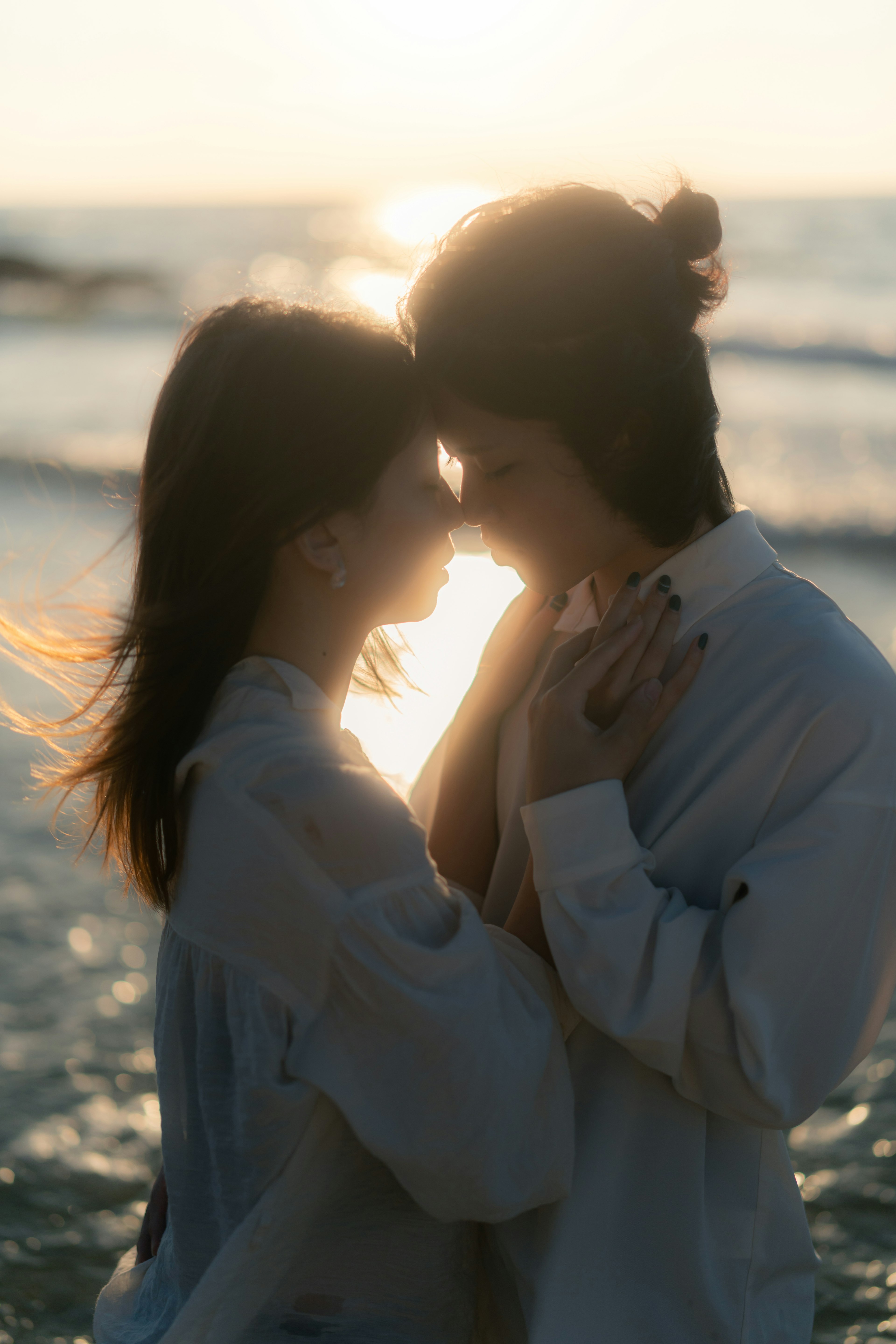 Silhouette eines Paares, das sich gegen den Sonnenuntergang am Strand umarmt