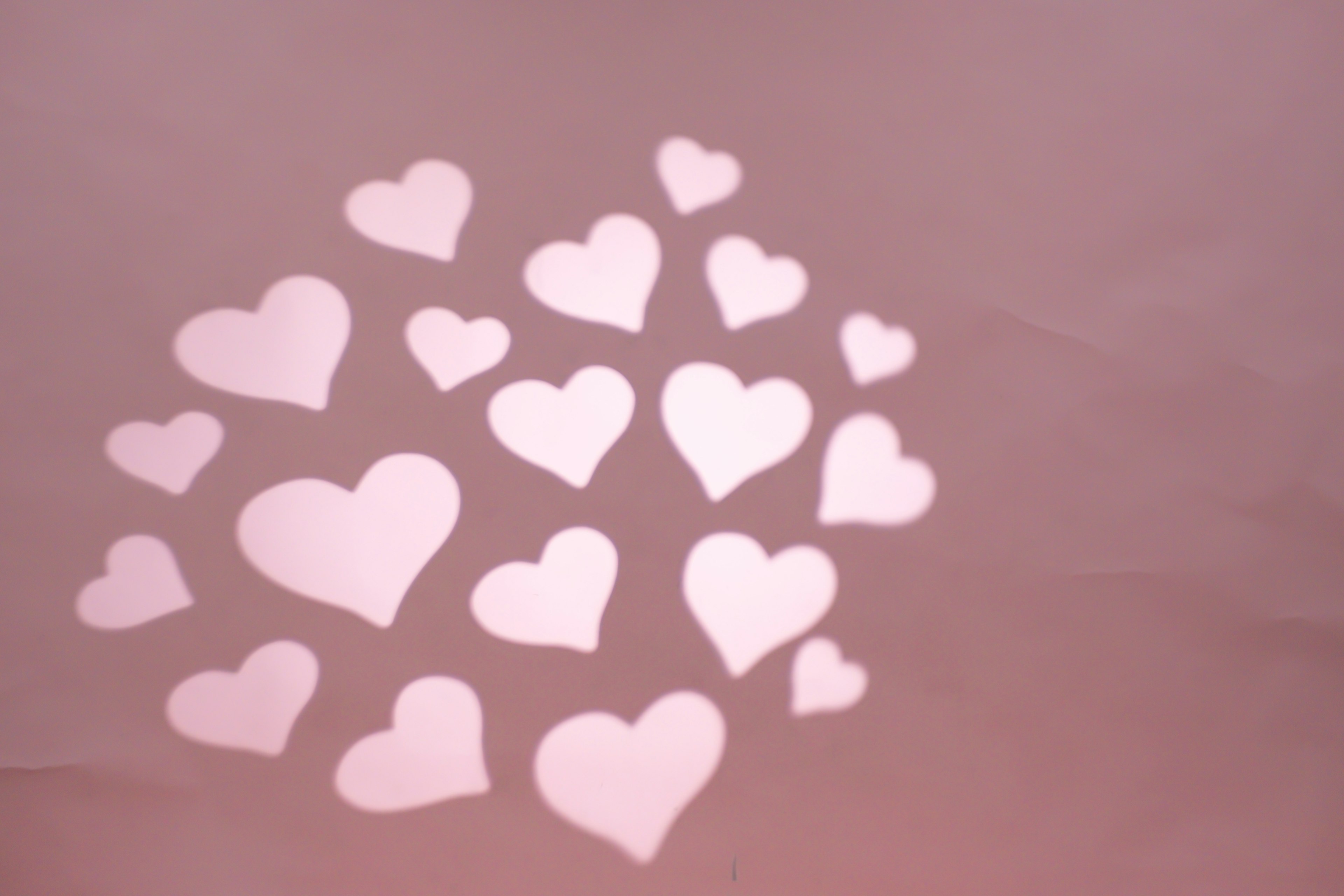 White hearts scattered on a light pink background