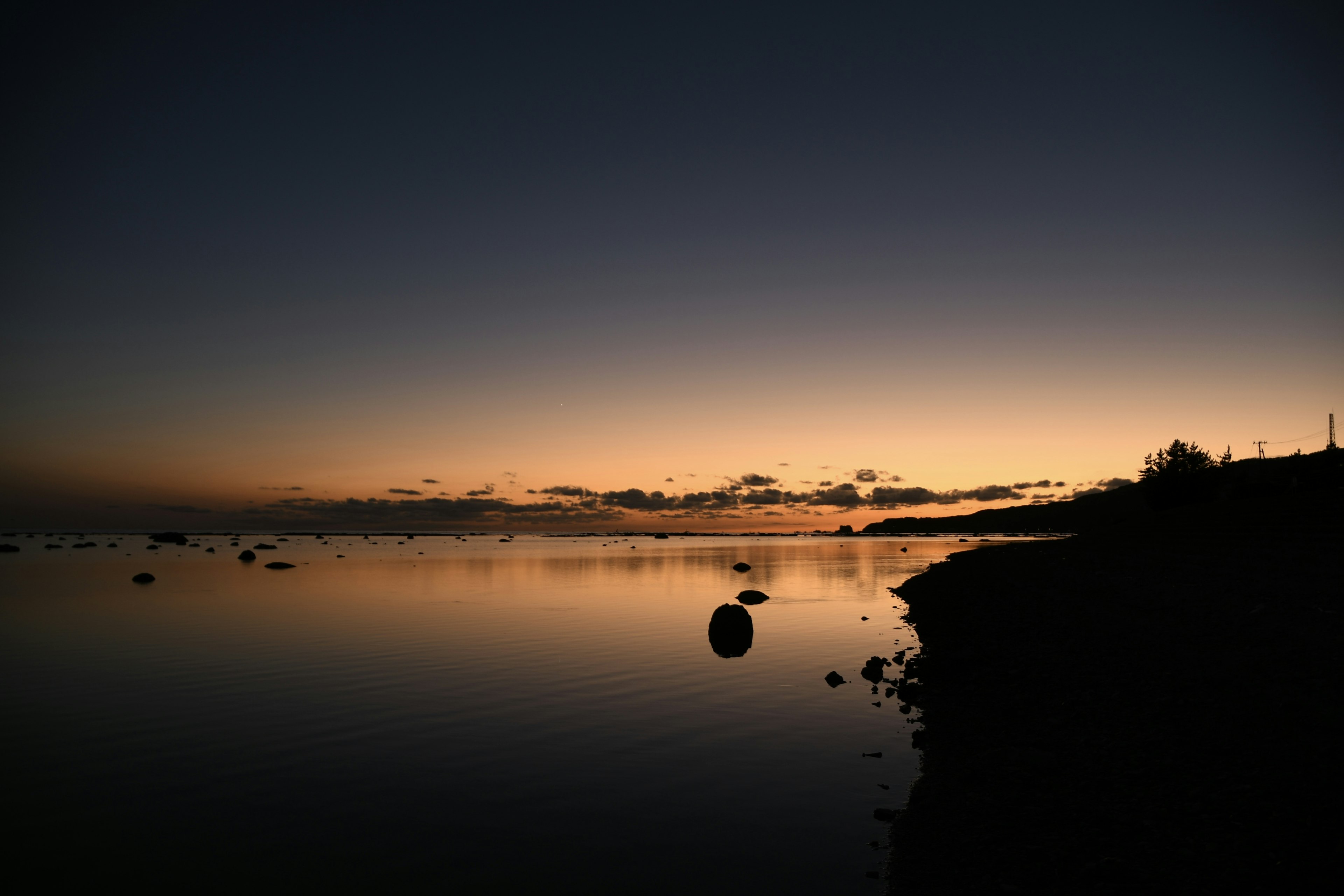 Paisaje sereno de atardecer sobre el mar con reflejos tranquilos en el agua