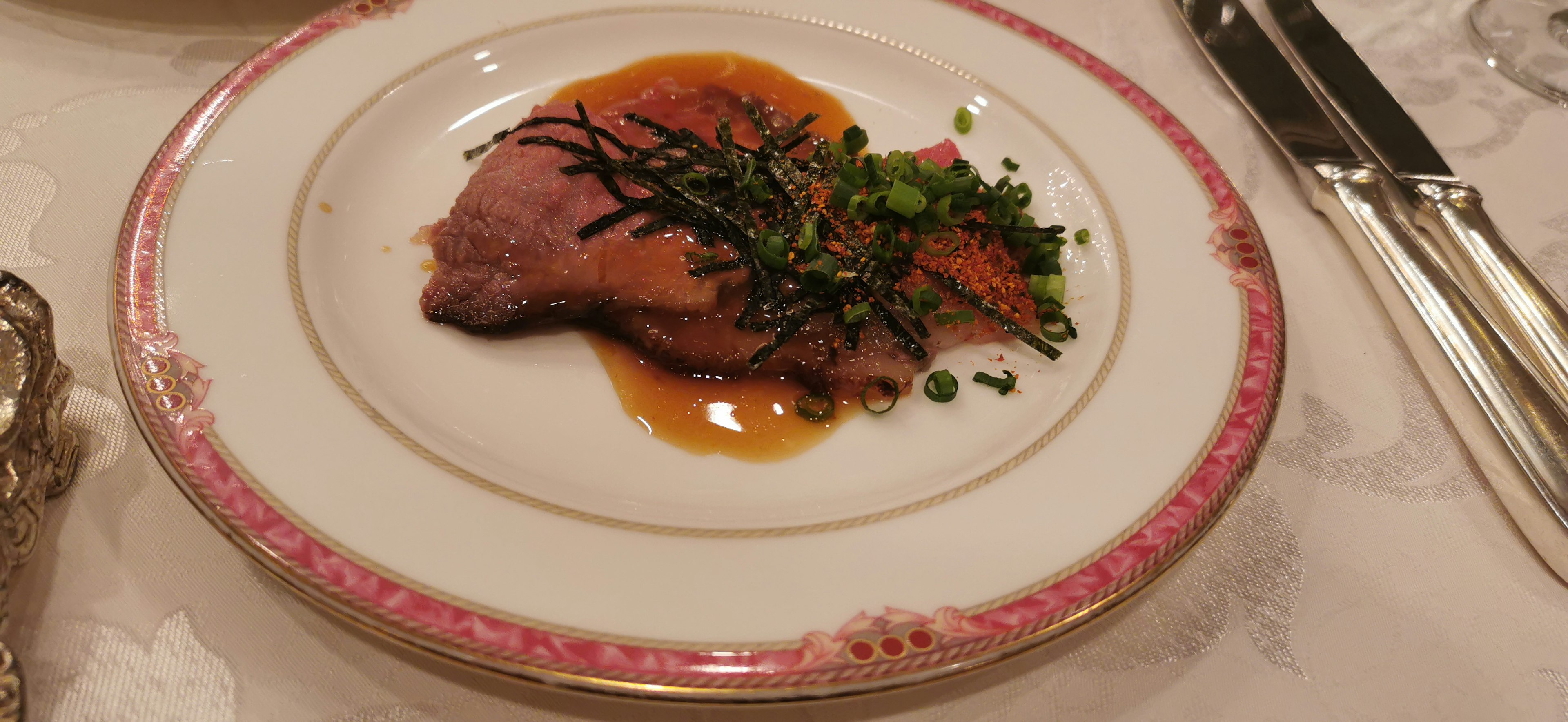 Assiette de plat de viande joliment présenté avec sauce et herbes