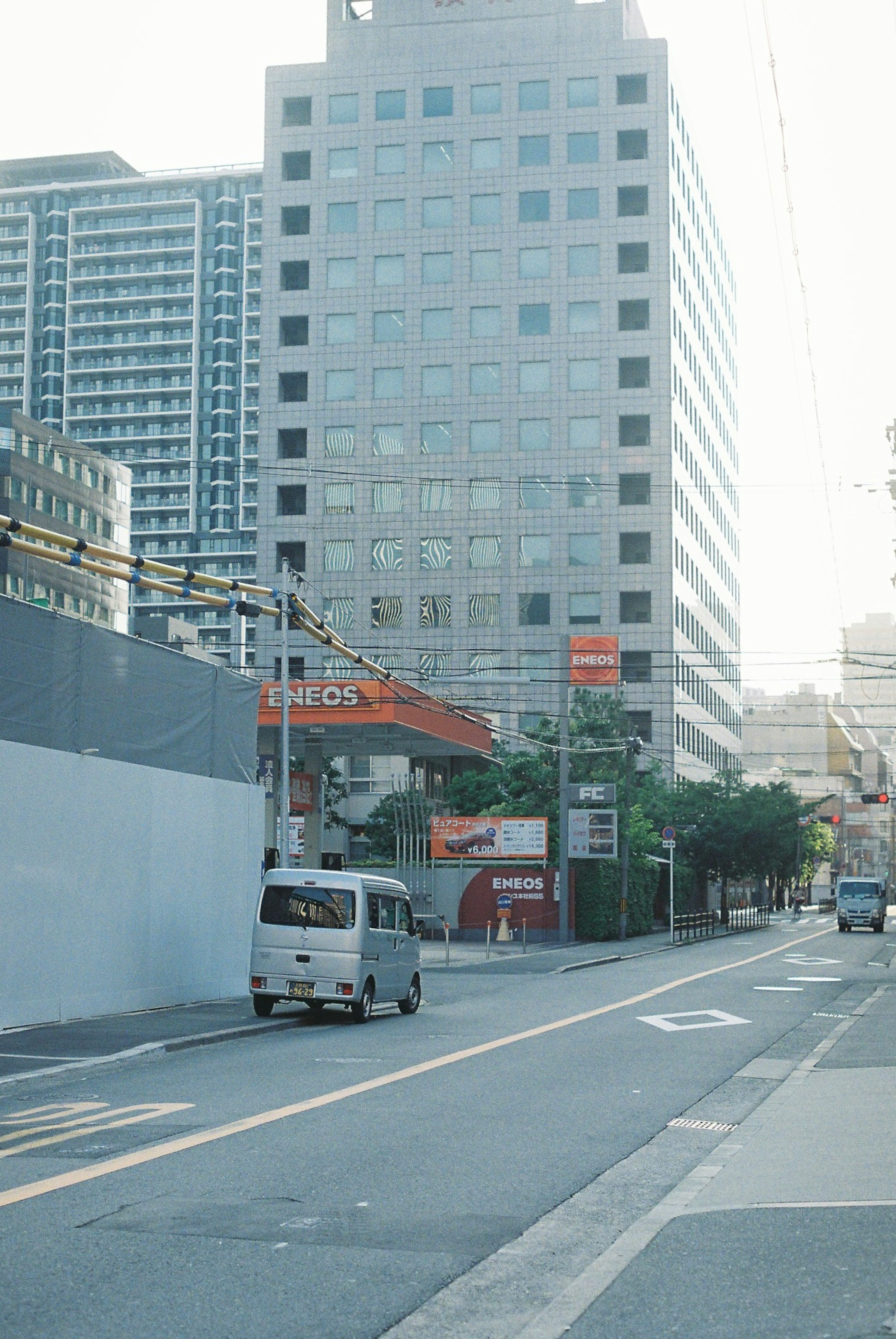 都市の通りにある高層ビルと小型バンの風景