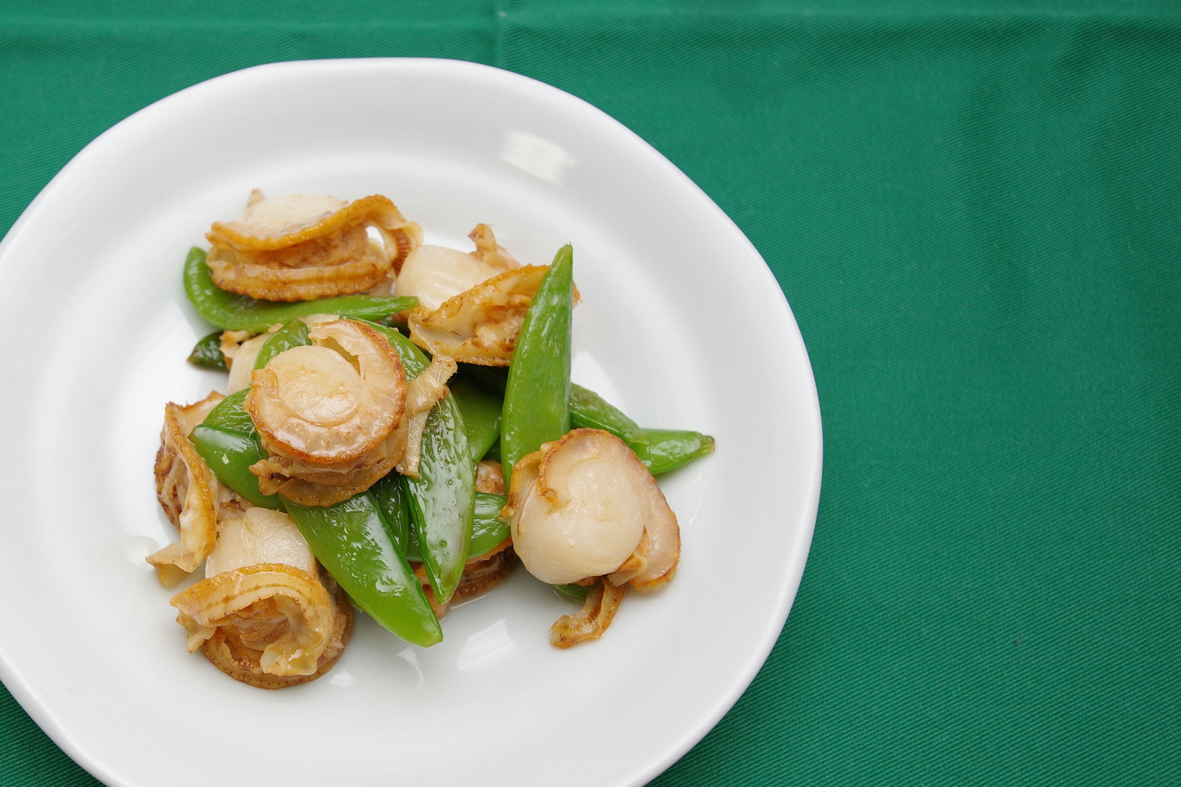 Plat de crevettes sautées et de pois mange-tout sur une assiette blanche