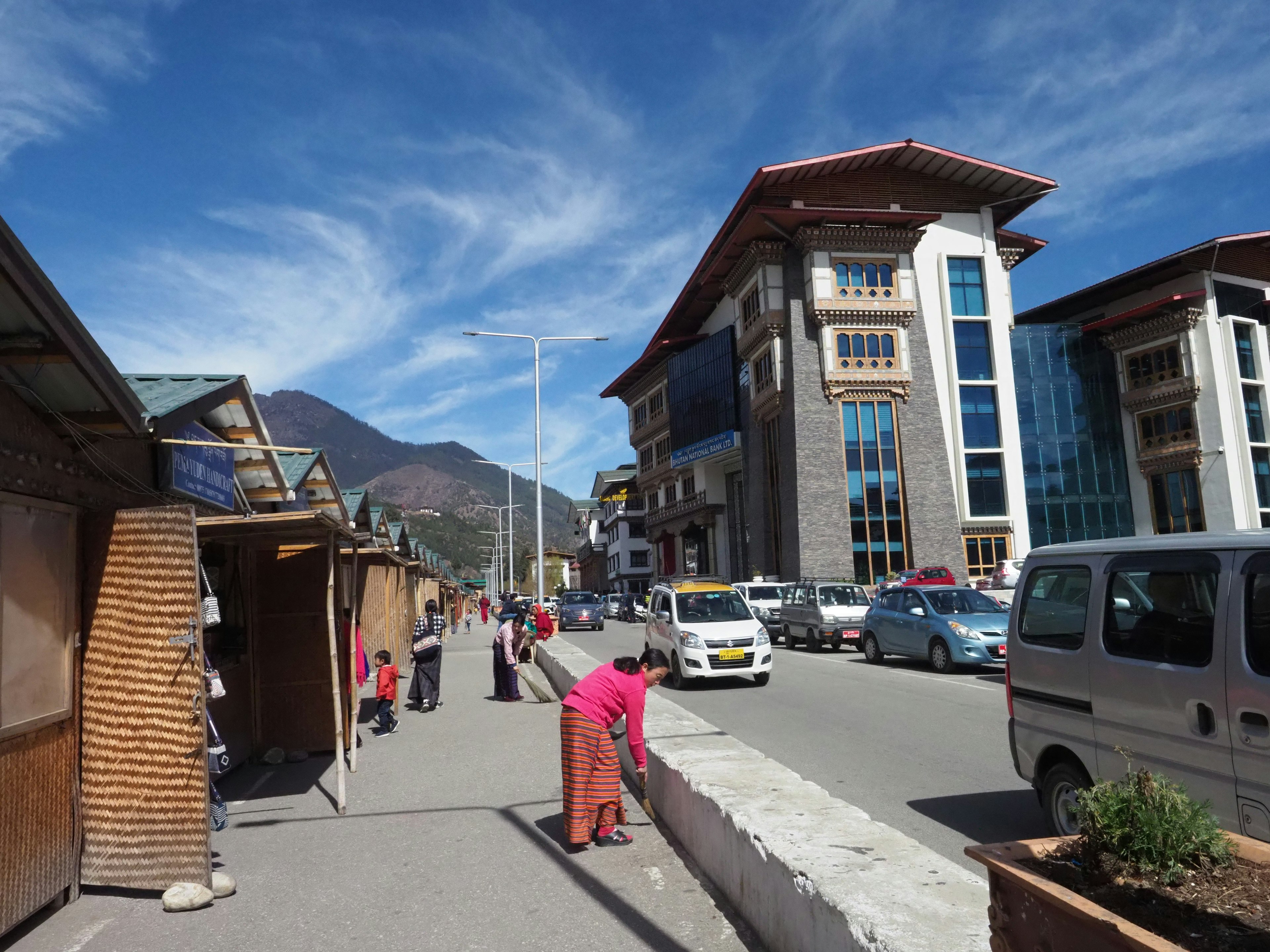 Straßenszene in Bhutan mit Fußgängern und modernen Gebäuden