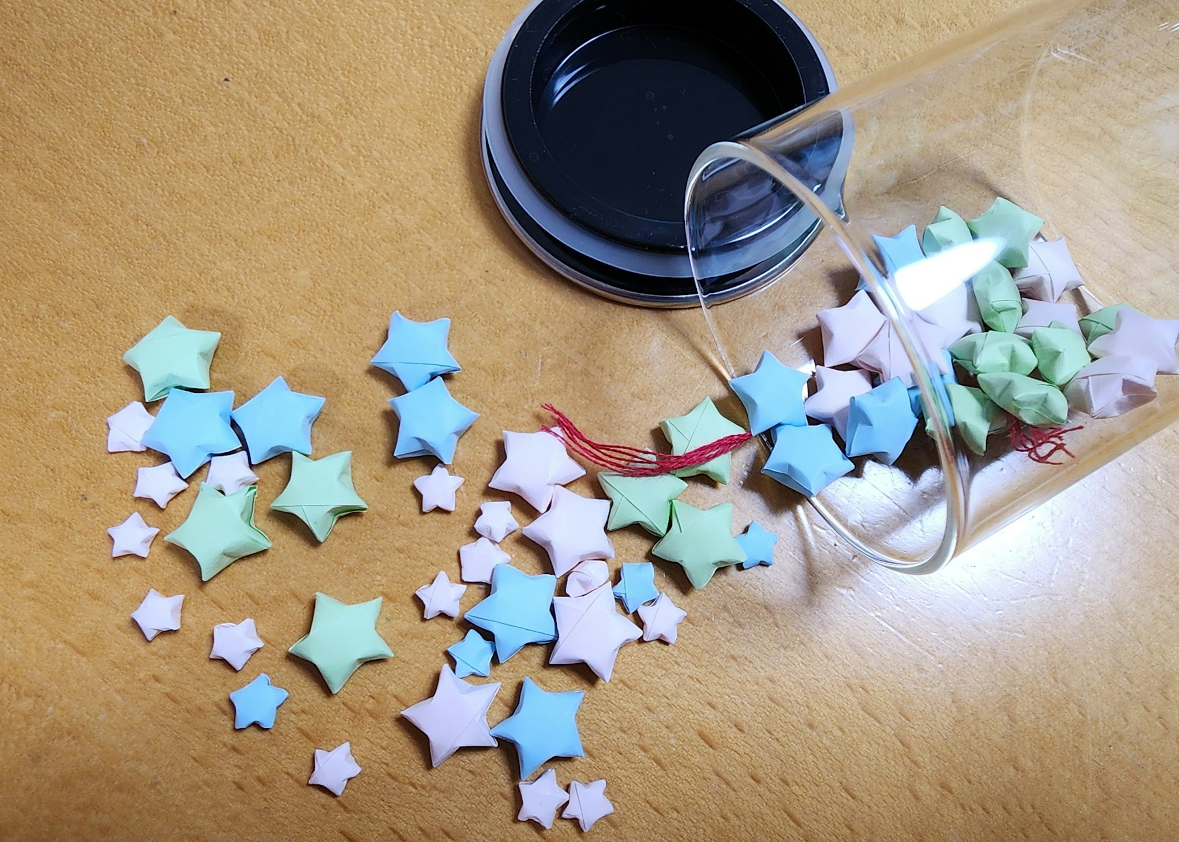 Colorful star-shaped decorations scattered around a transparent container spilling out