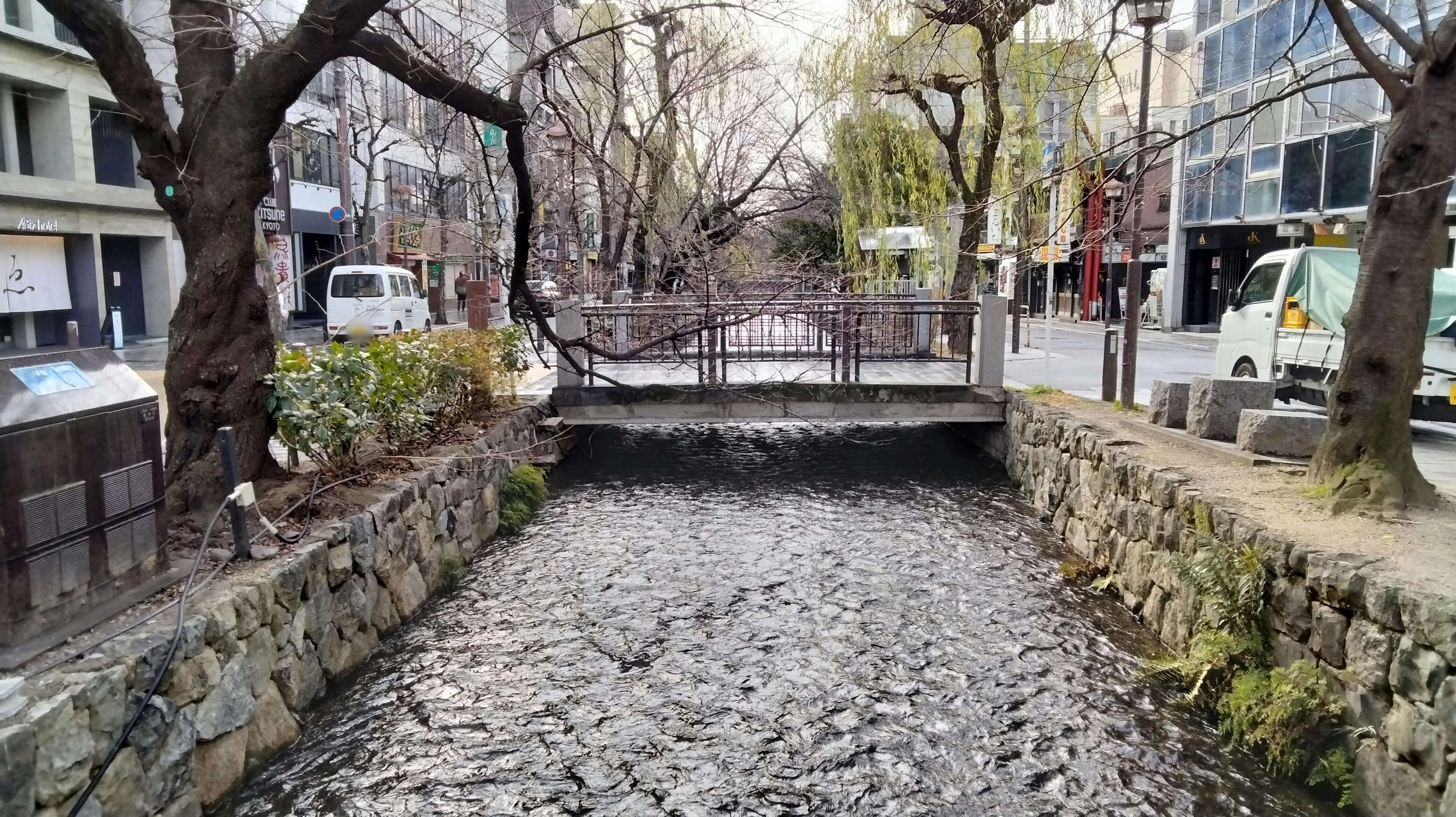 Scène urbaine avec une rivière calme et un petit pont