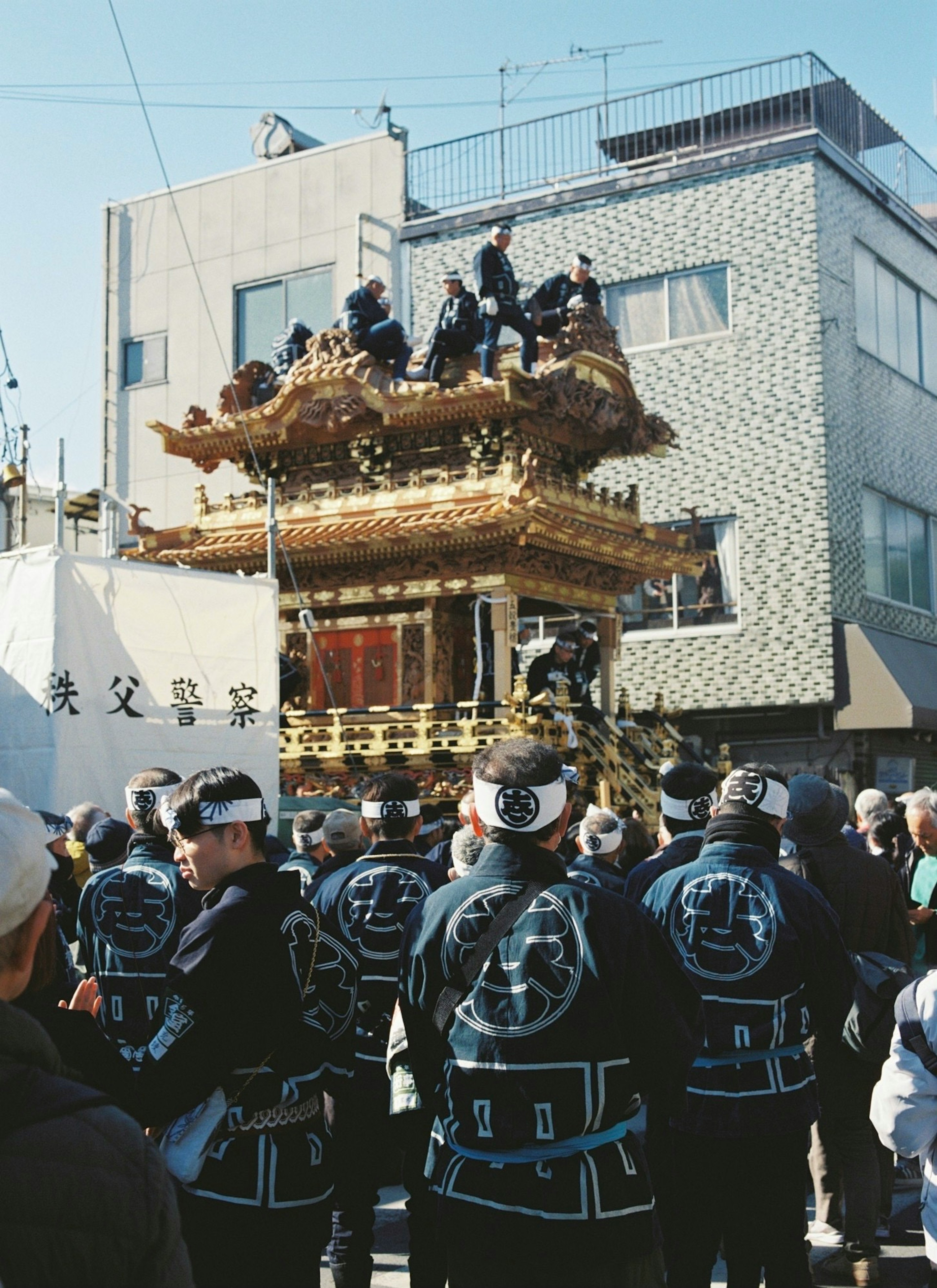 祭りのために飾られた豪華な神輿とそれを囲む人々の姿