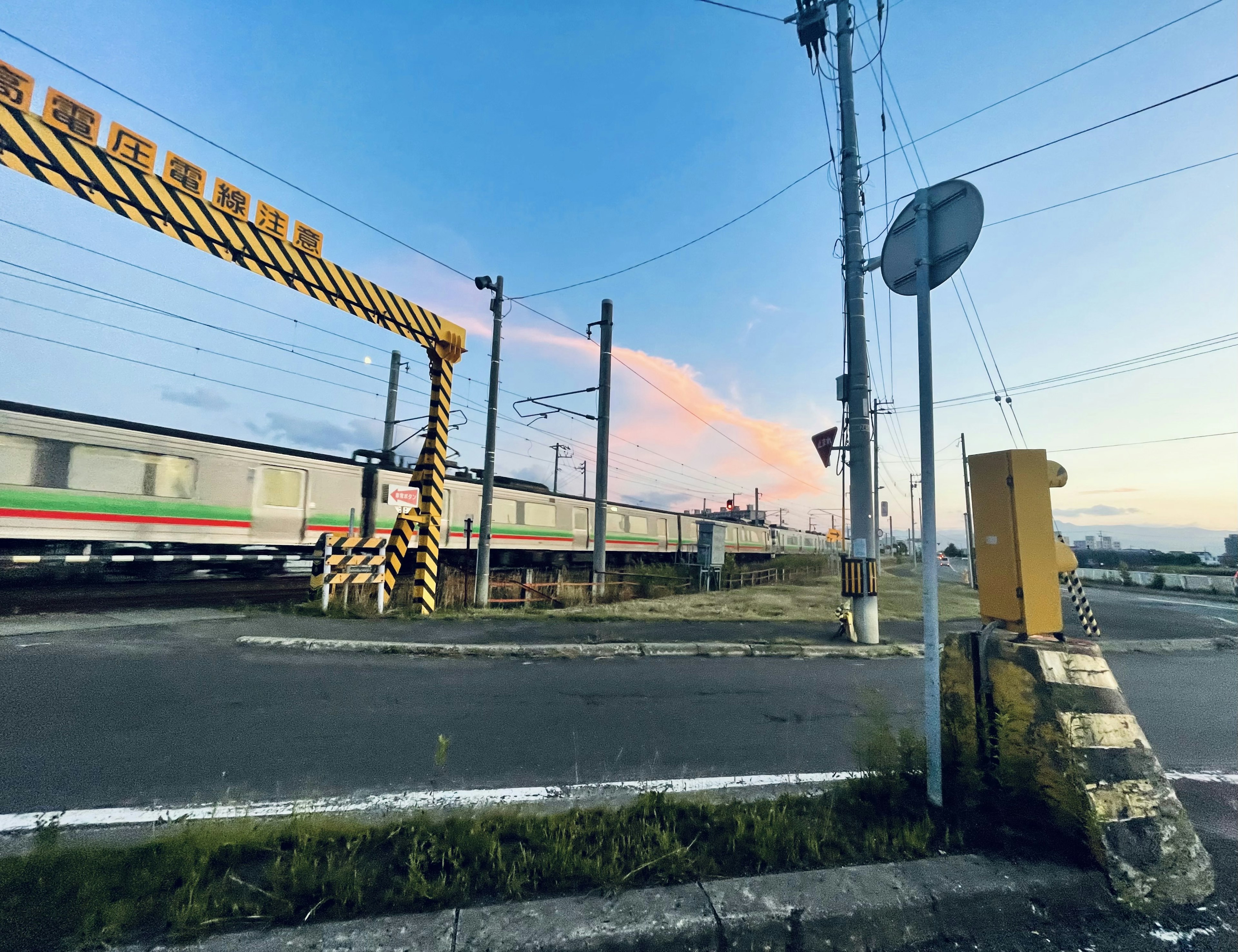 ท้องฟ้ายามพระอาทิตย์ตกกับทิวทัศน์ทางรถไฟ ถนนใกล้สัญญาณจราจรและรางรถไฟ