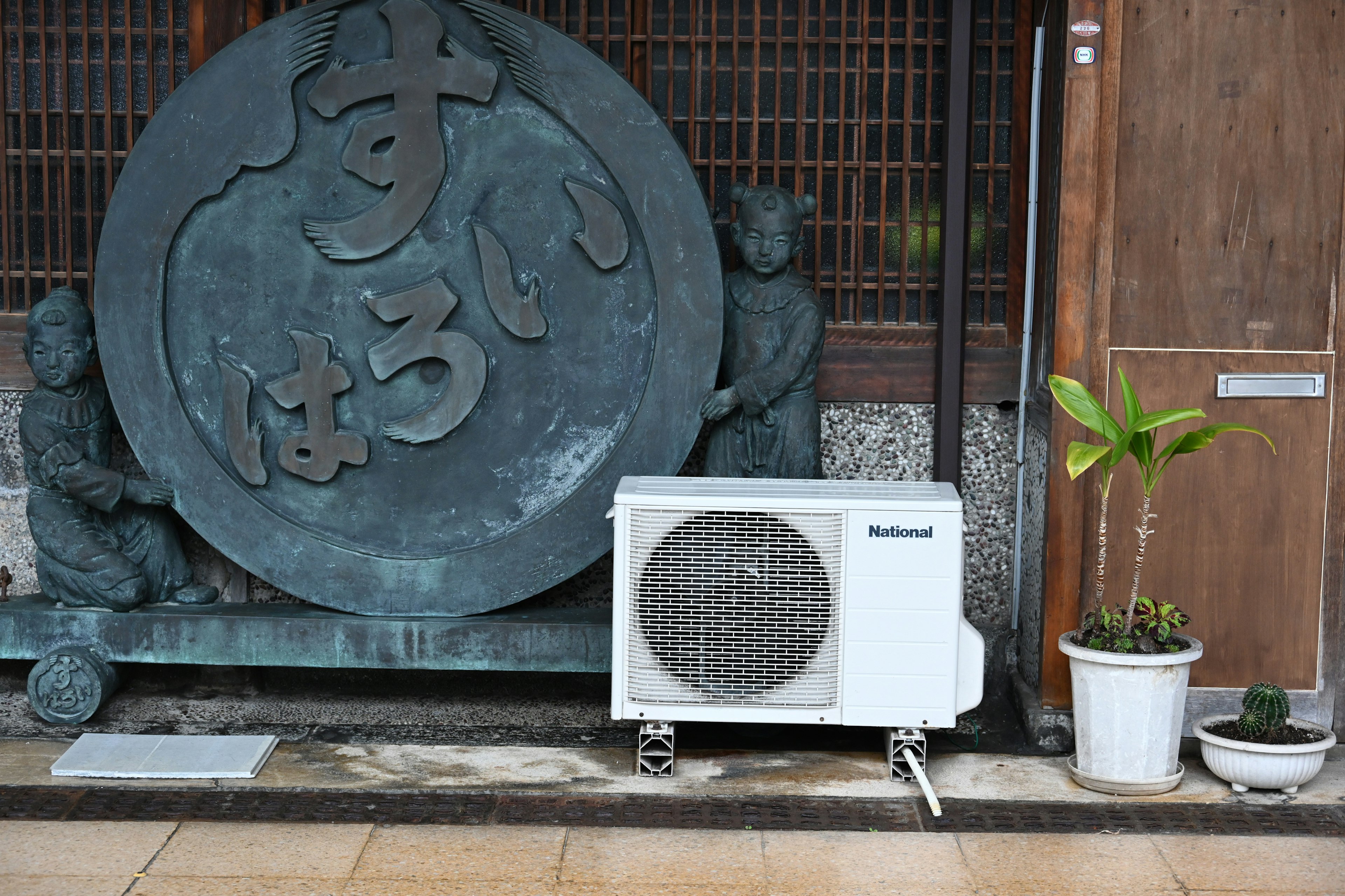 大きな石の彫刻とエアコンが置かれた外観の景観