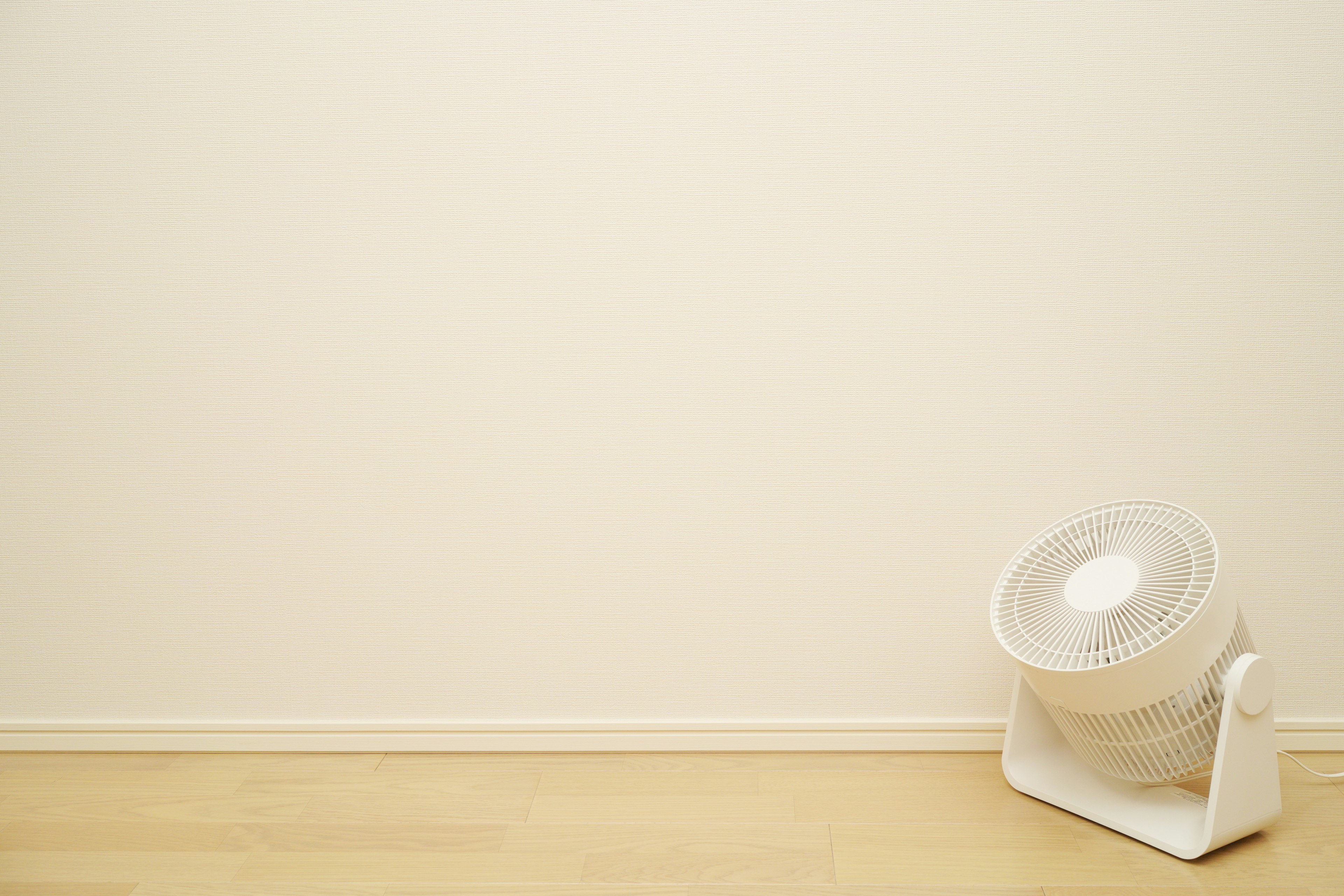 White wall with a white light fixture on the floor