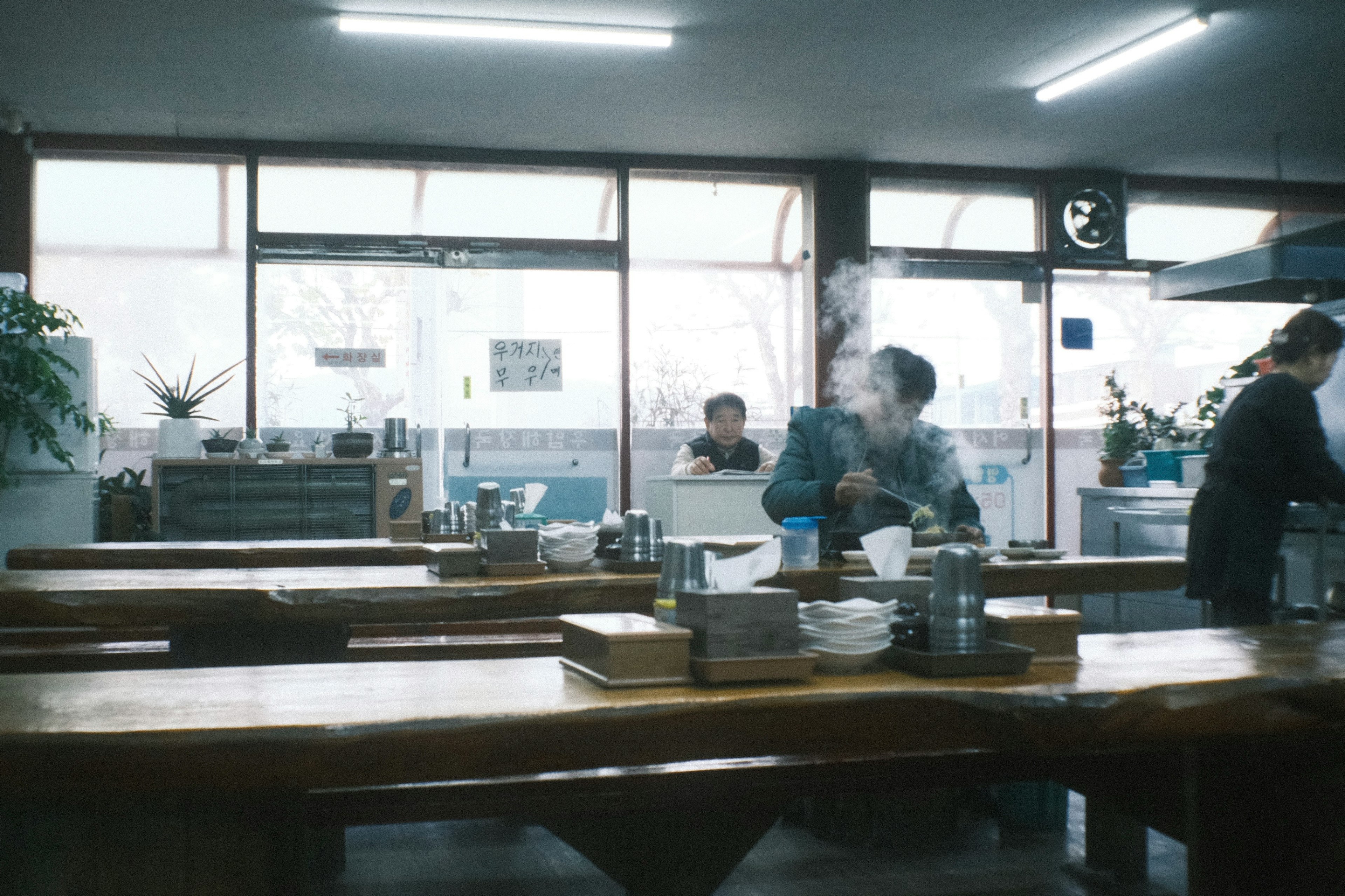 Interior of a restaurant with a chef cooking and steam rising