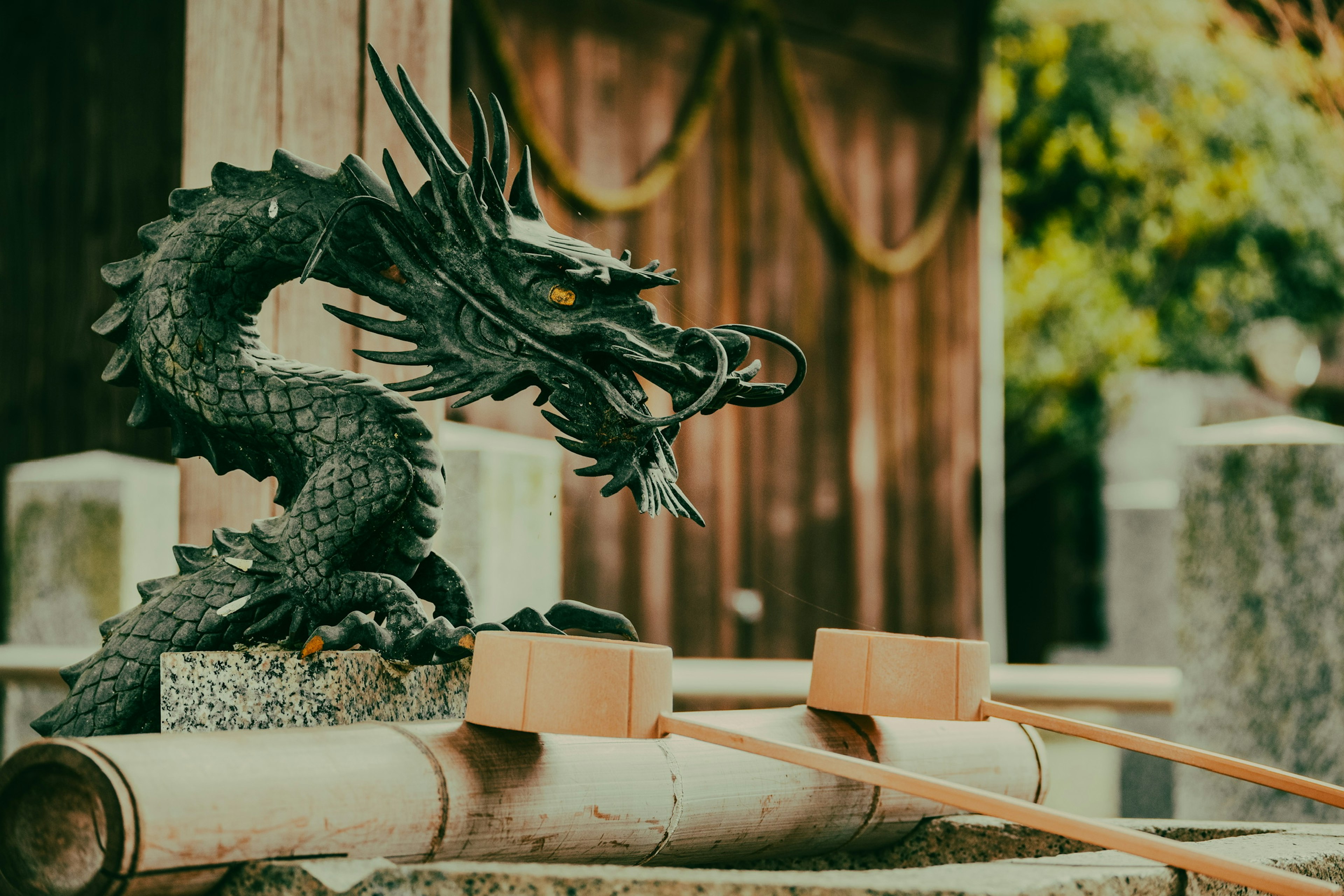 Escultura de dragón negro con fuentes de agua de bambú en un santuario