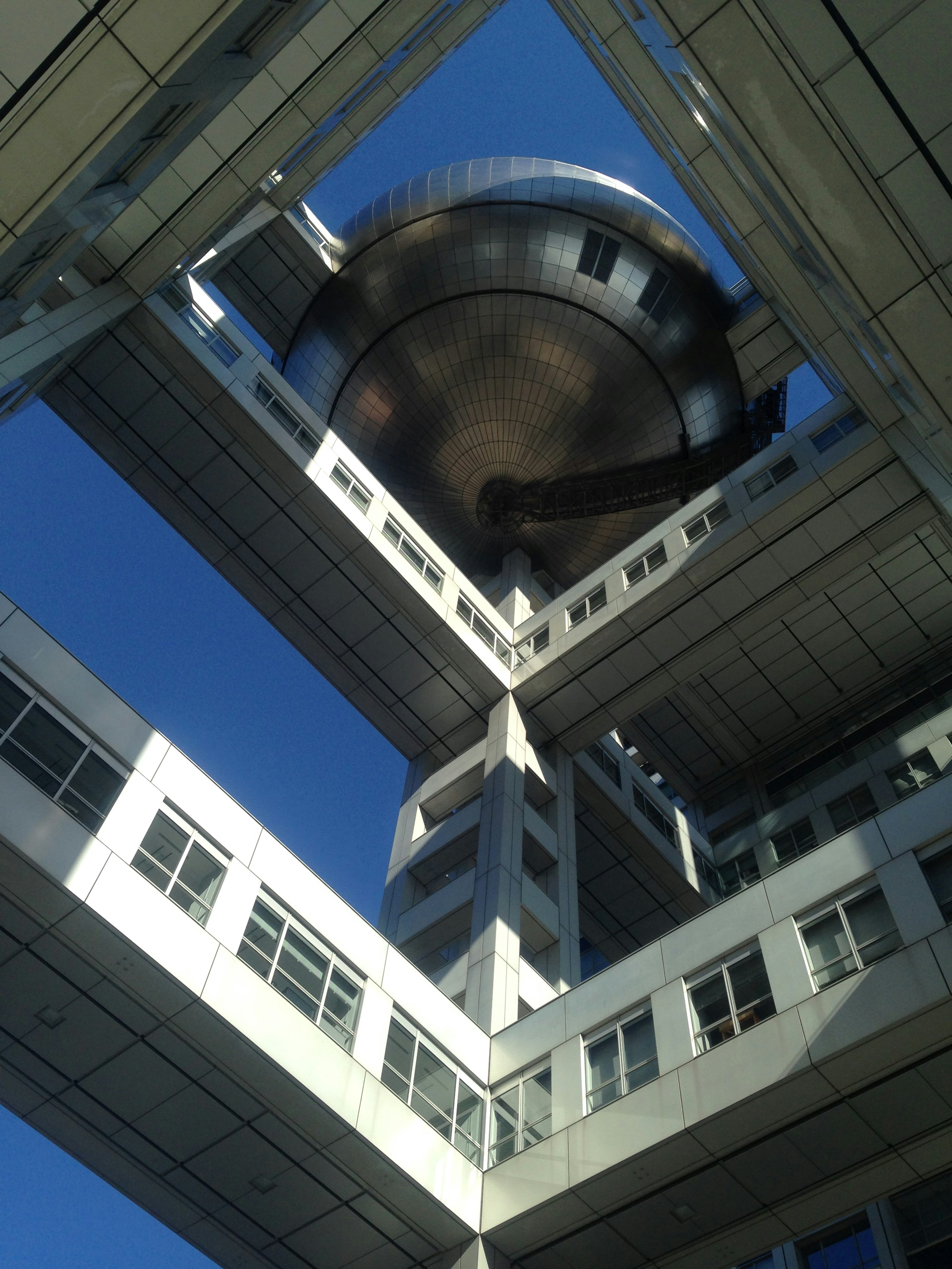 View from below of a building's interior structure with a spherical observation deck