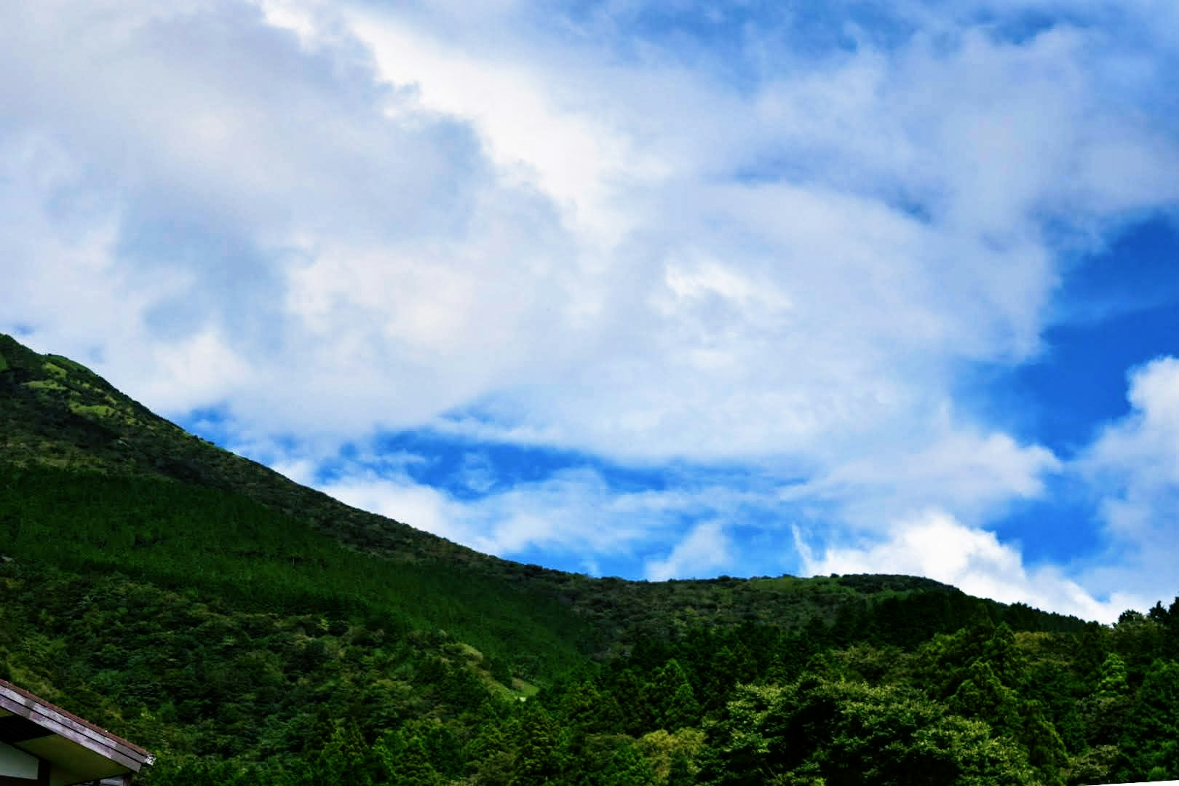 Pemandangan pegunungan dengan langit biru dan awan putih