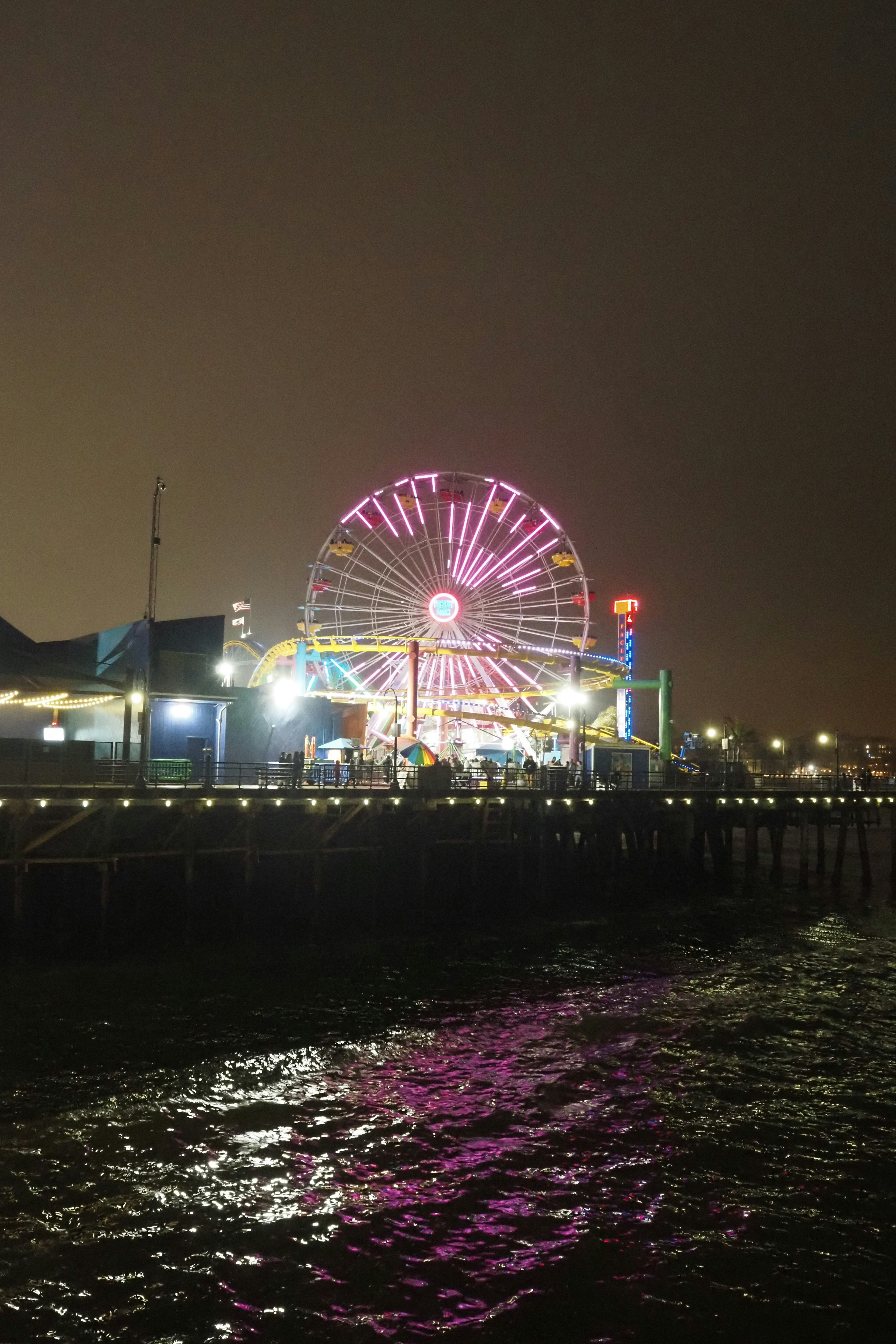 Lampu berwarna-warni dari bianglala di Santa Monica Pier di malam hari