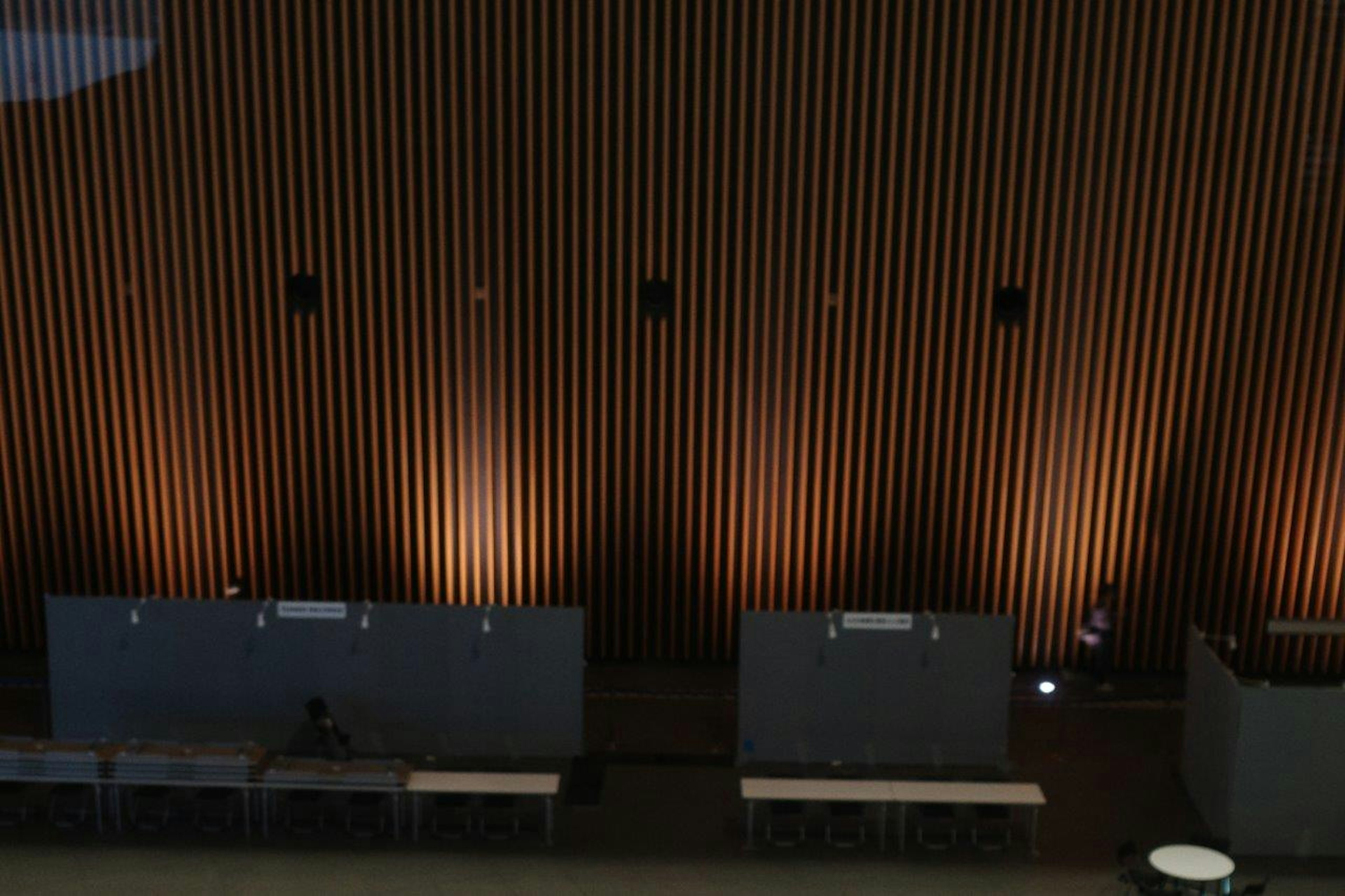 Image of an indoor space featuring wooden wall panels and ambient lighting