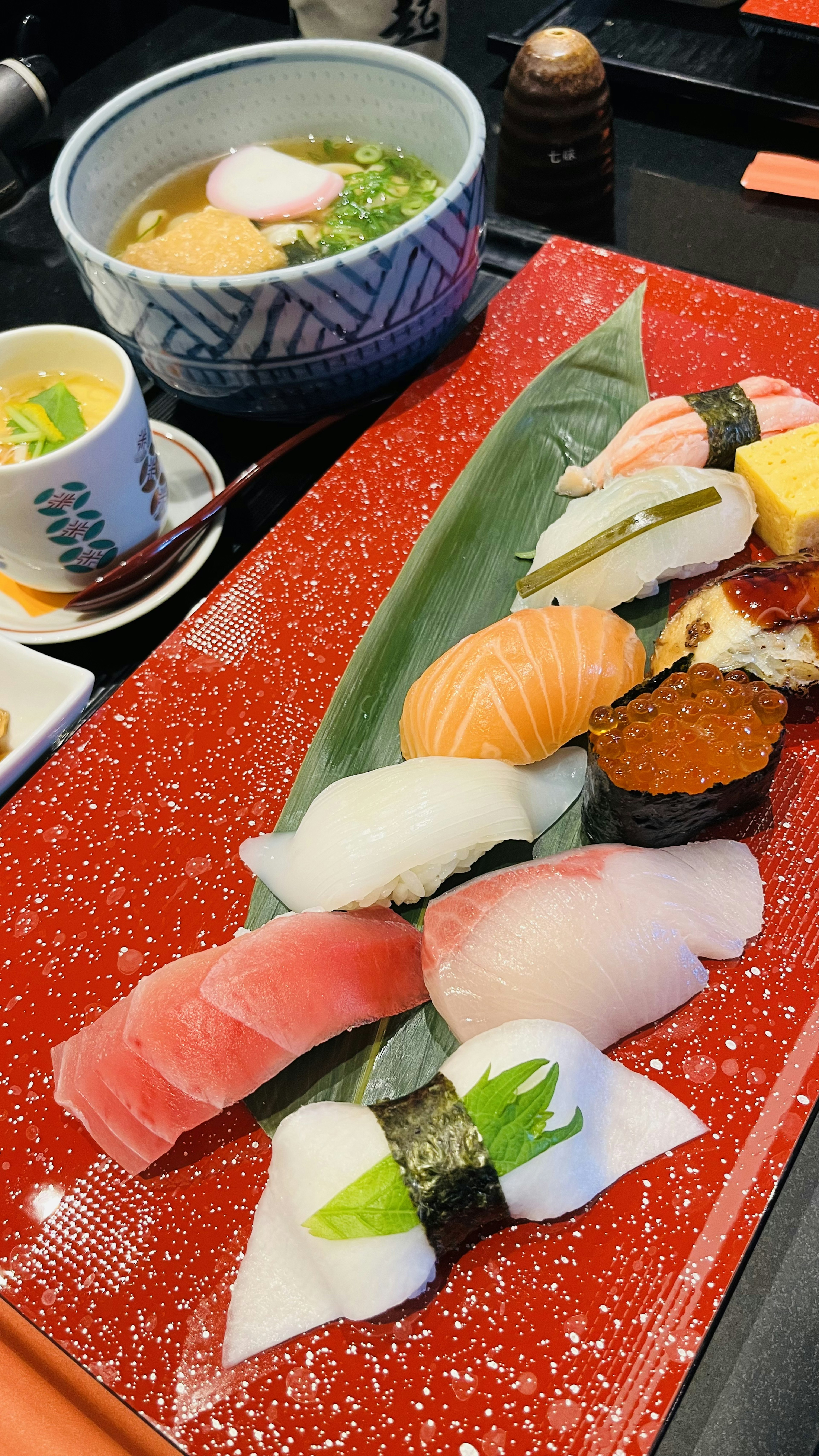 Colorful sushi beautifully arranged on a plate with miso soup