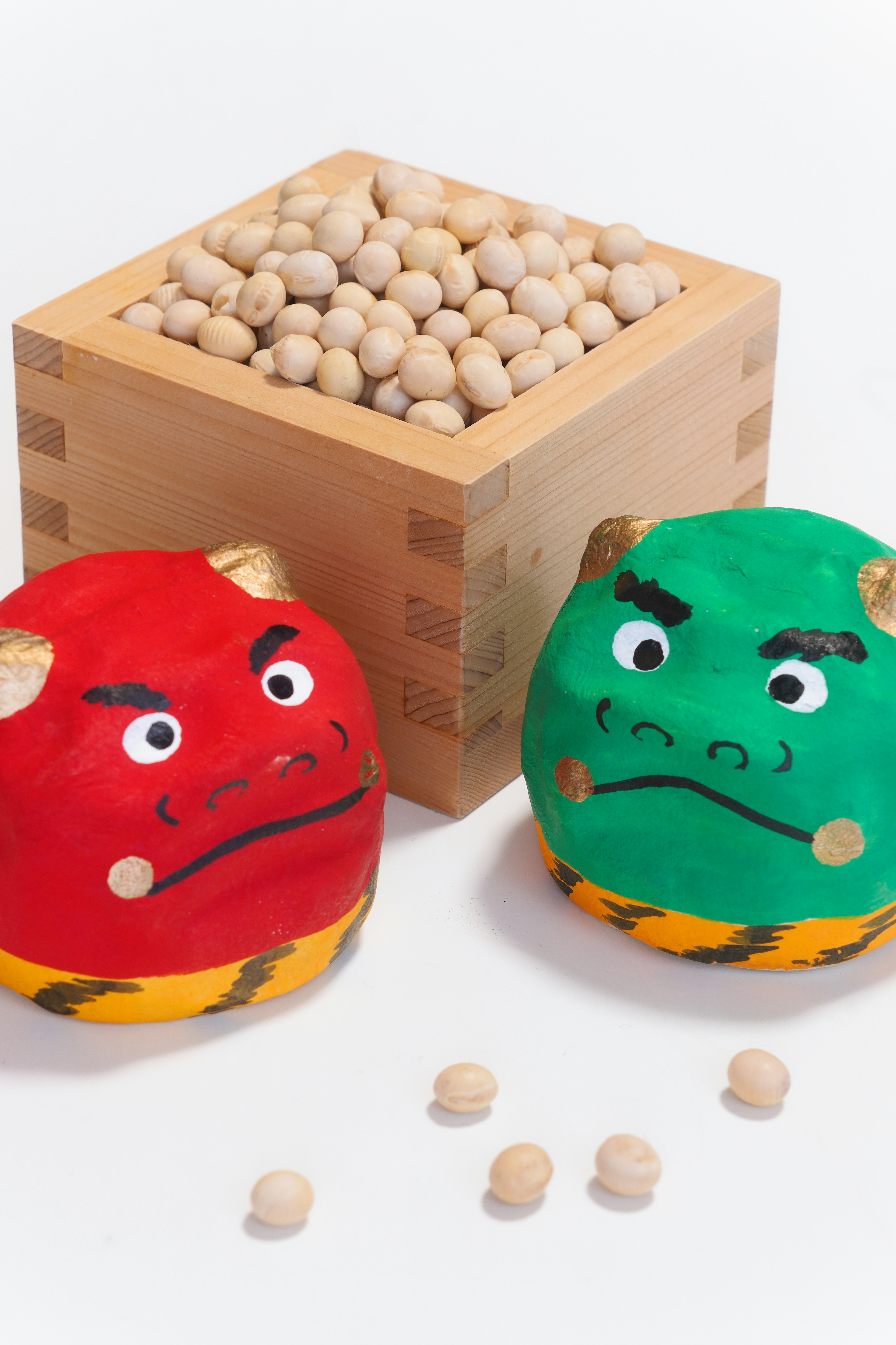 Red and green demon characters with a wooden box of beans