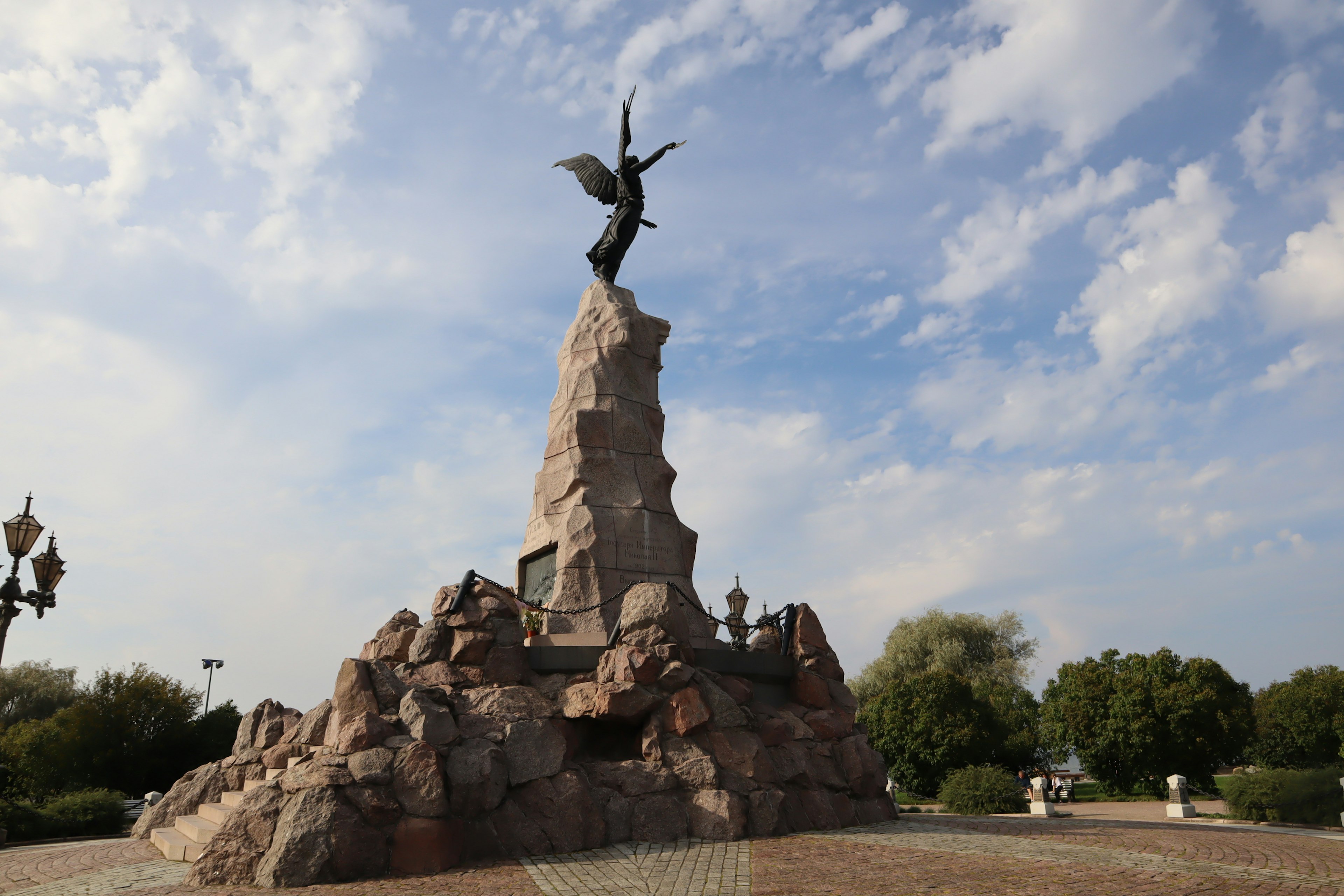 Engelsstatue, die auf einem felsigen Denkmal emporsteigt