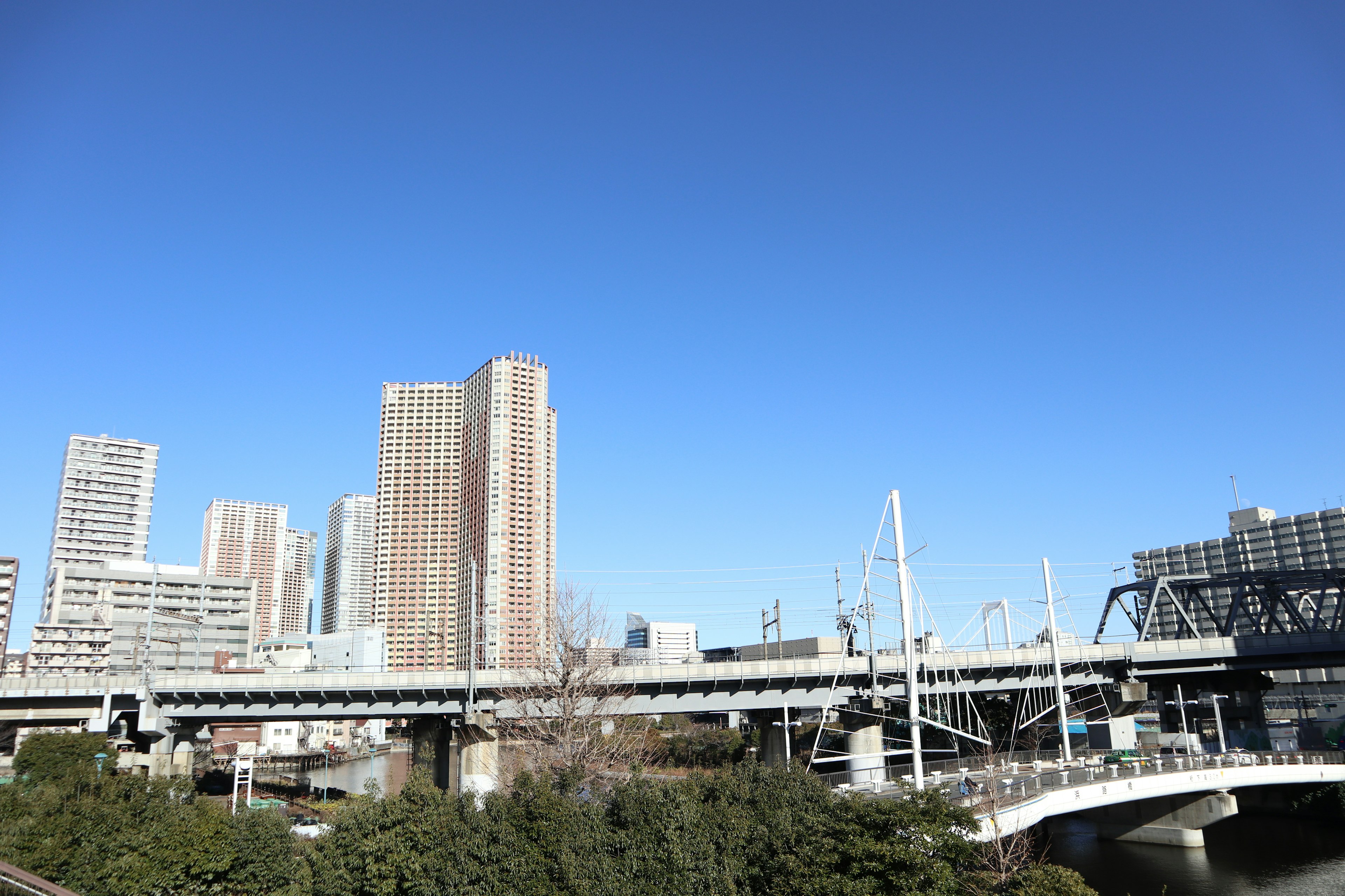 青空の下に高層ビルと橋が見える都市の風景