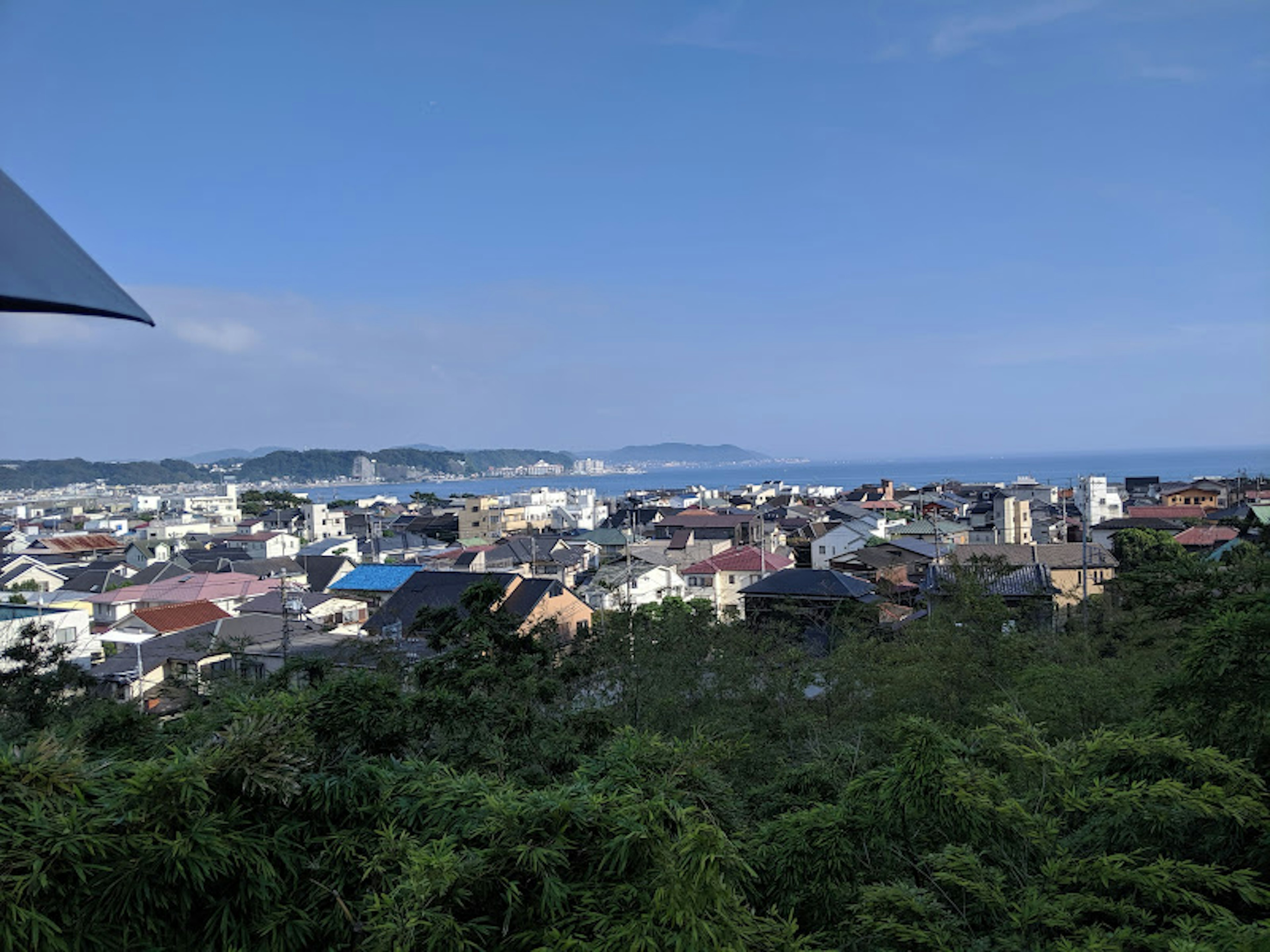 Panoramic view of a town with blue sky and ocean in the background