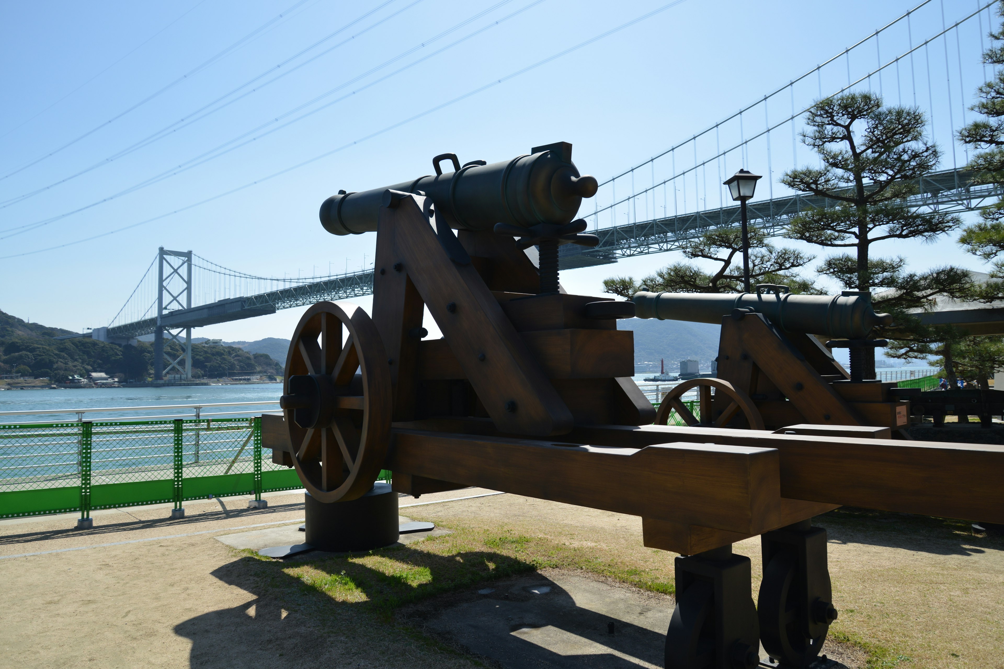 Model of an old cannon in front of a bridge over the Seto Inland Sea