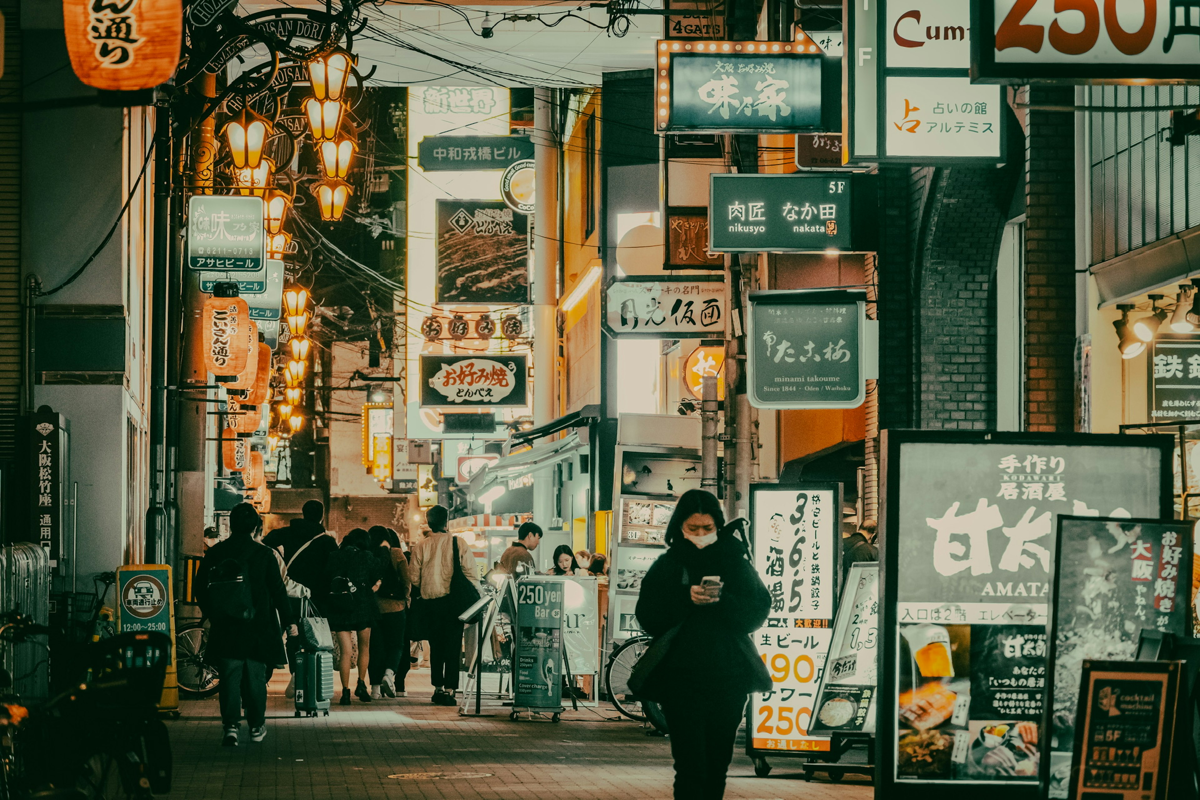 Calle bulliciosa con letreros de restaurantes y personas