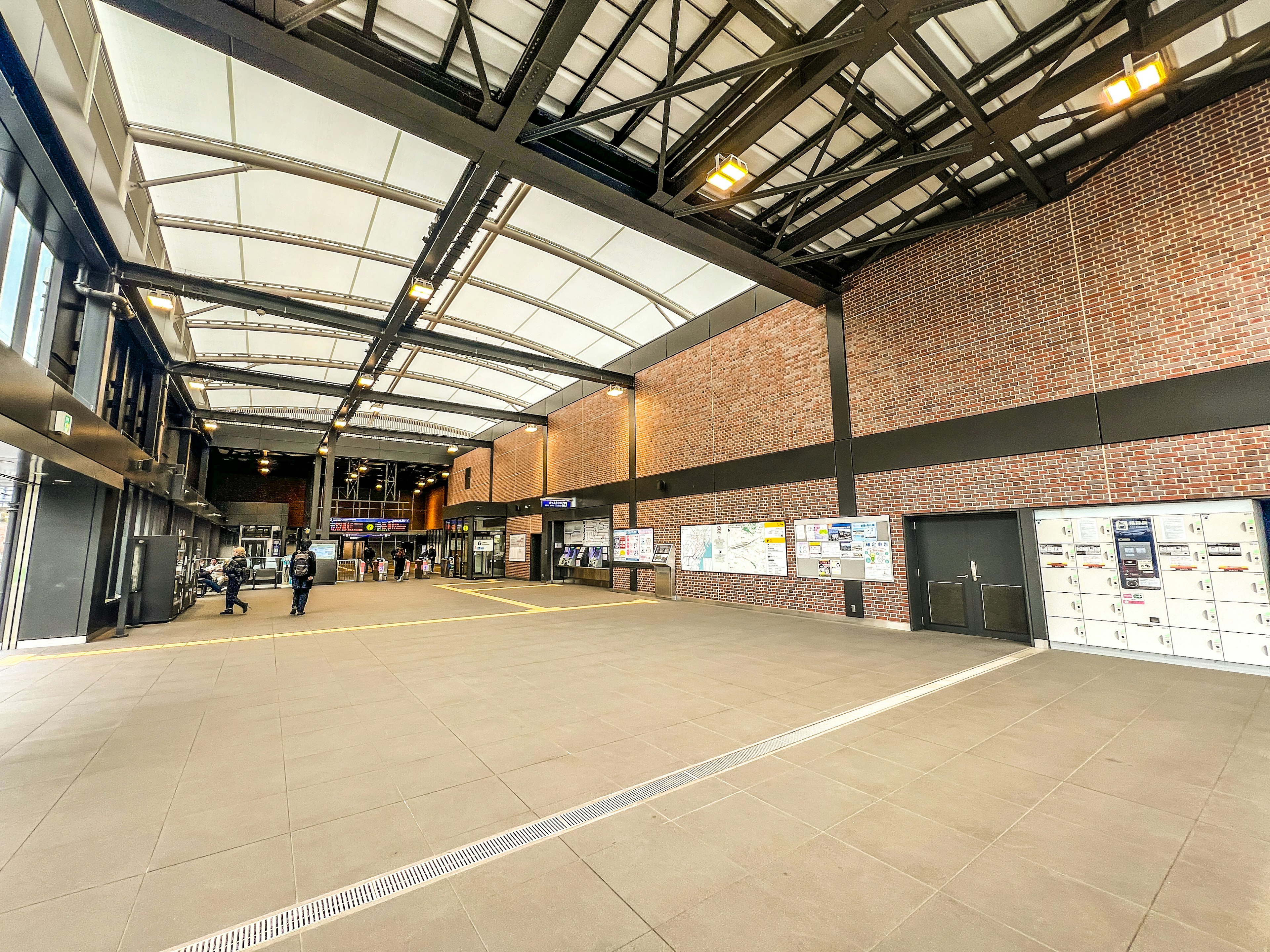 Spacious modern hall with people walking high ceiling and open space brick walls