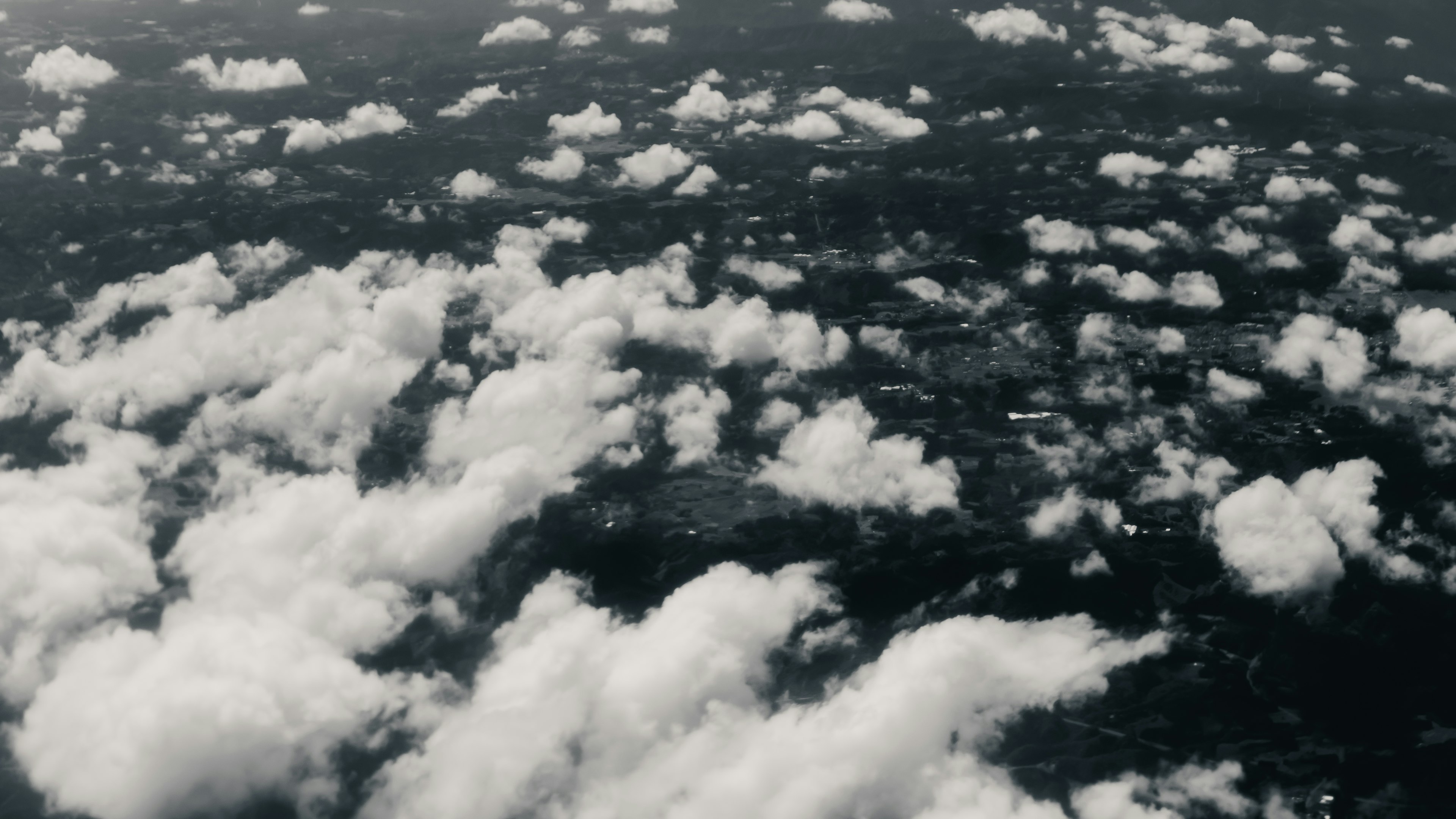 Aerial view of clouds and landscape with white clouds and green terrain