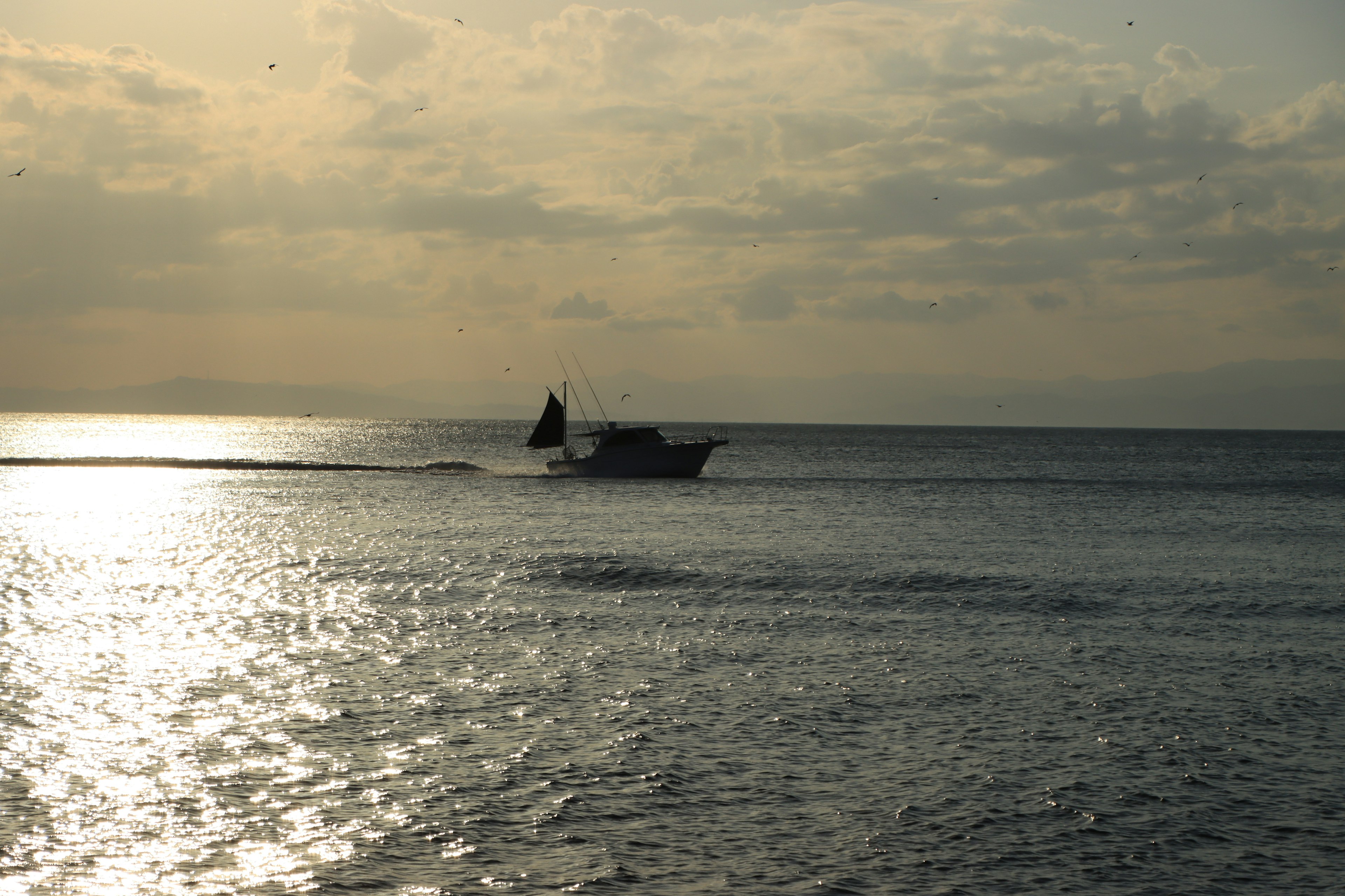 Una piccola barca che naviga su acque tranquille al tramonto