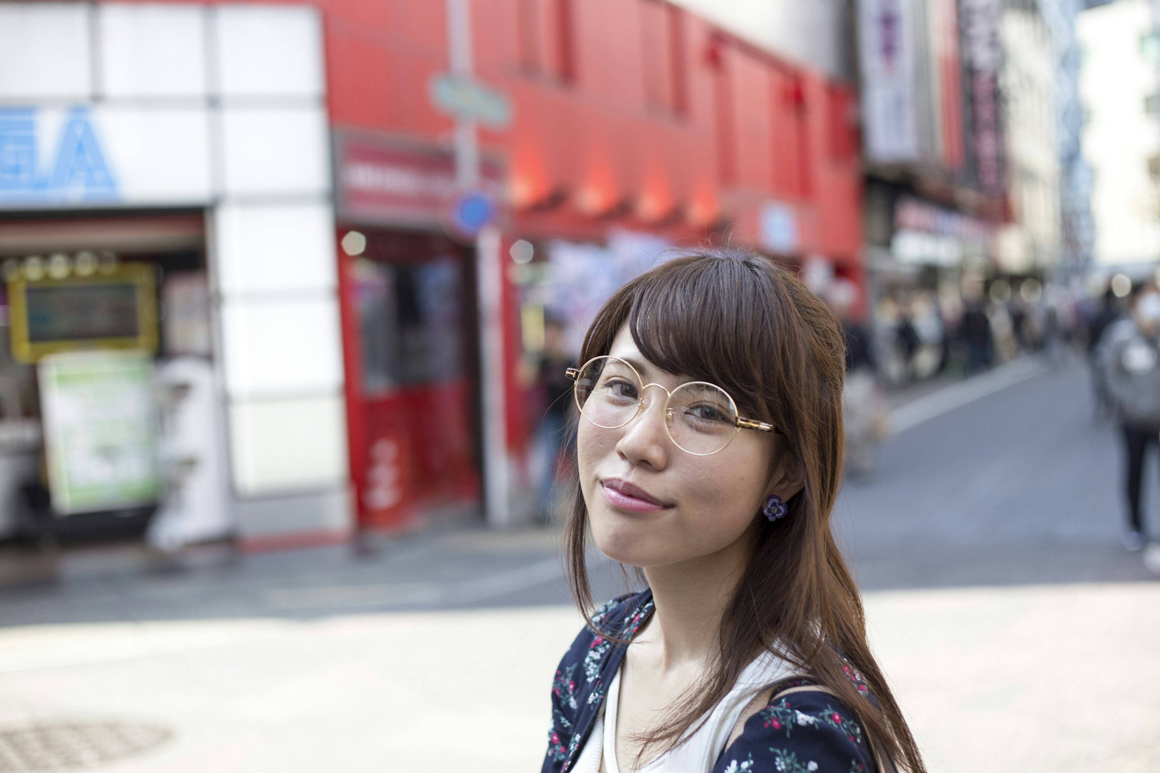 Portrait d'une femme souriante devant un bâtiment rouge