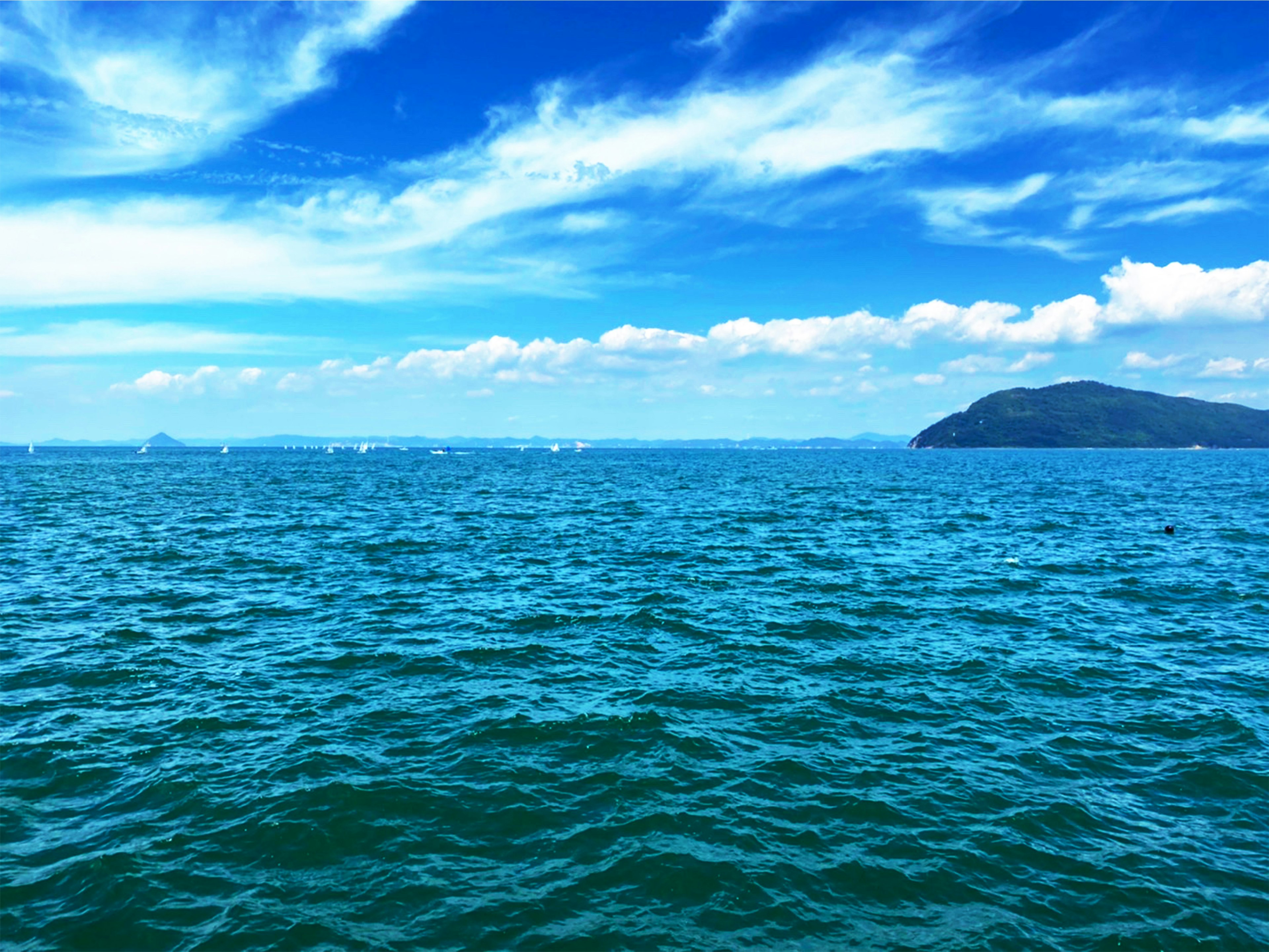 Pemandangan indah laut biru dan langit dengan sebuah pulau kecil