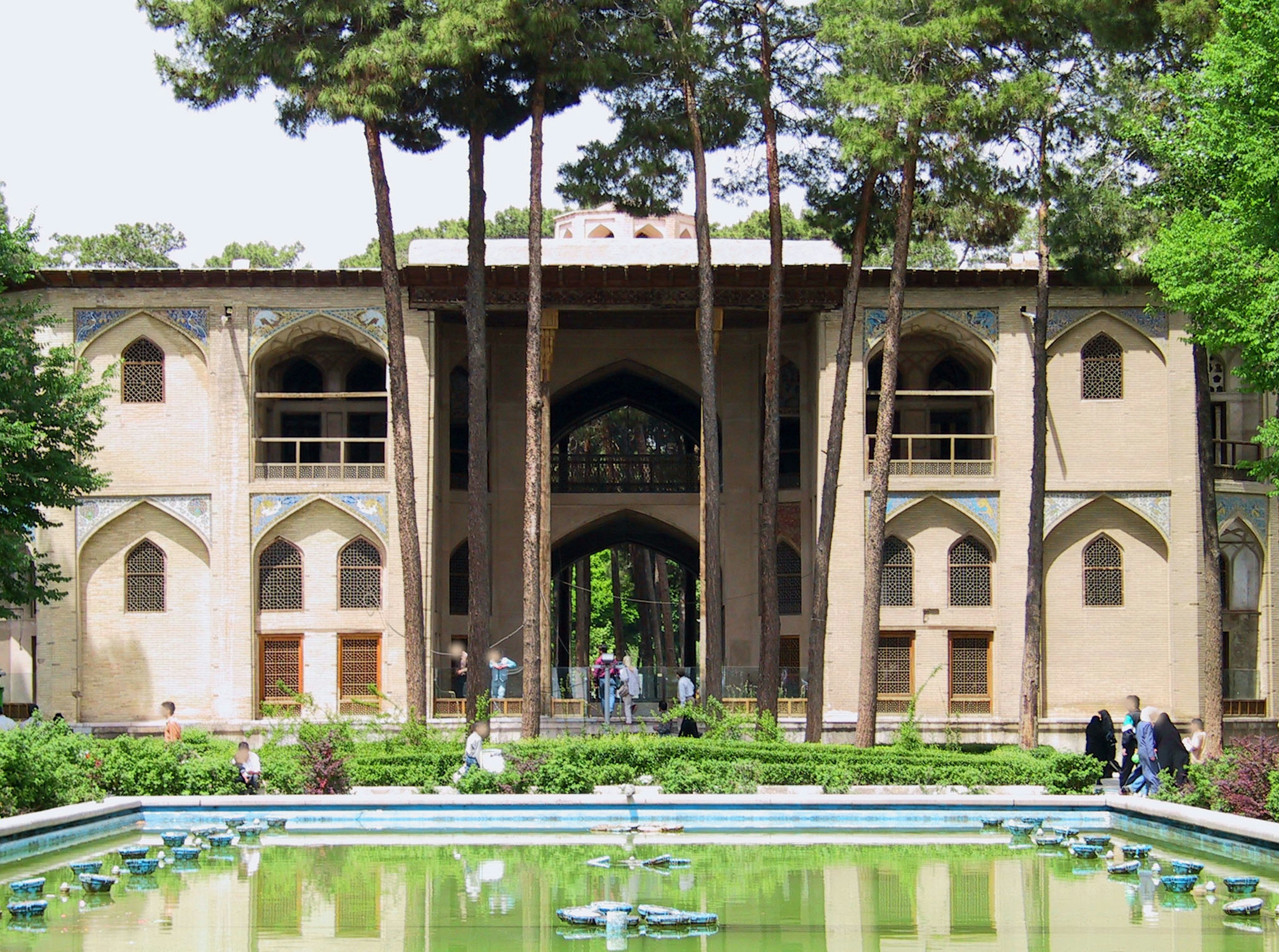 Bâtiment historique avec un beau jardin comportant des arbres luxuriants et un étang