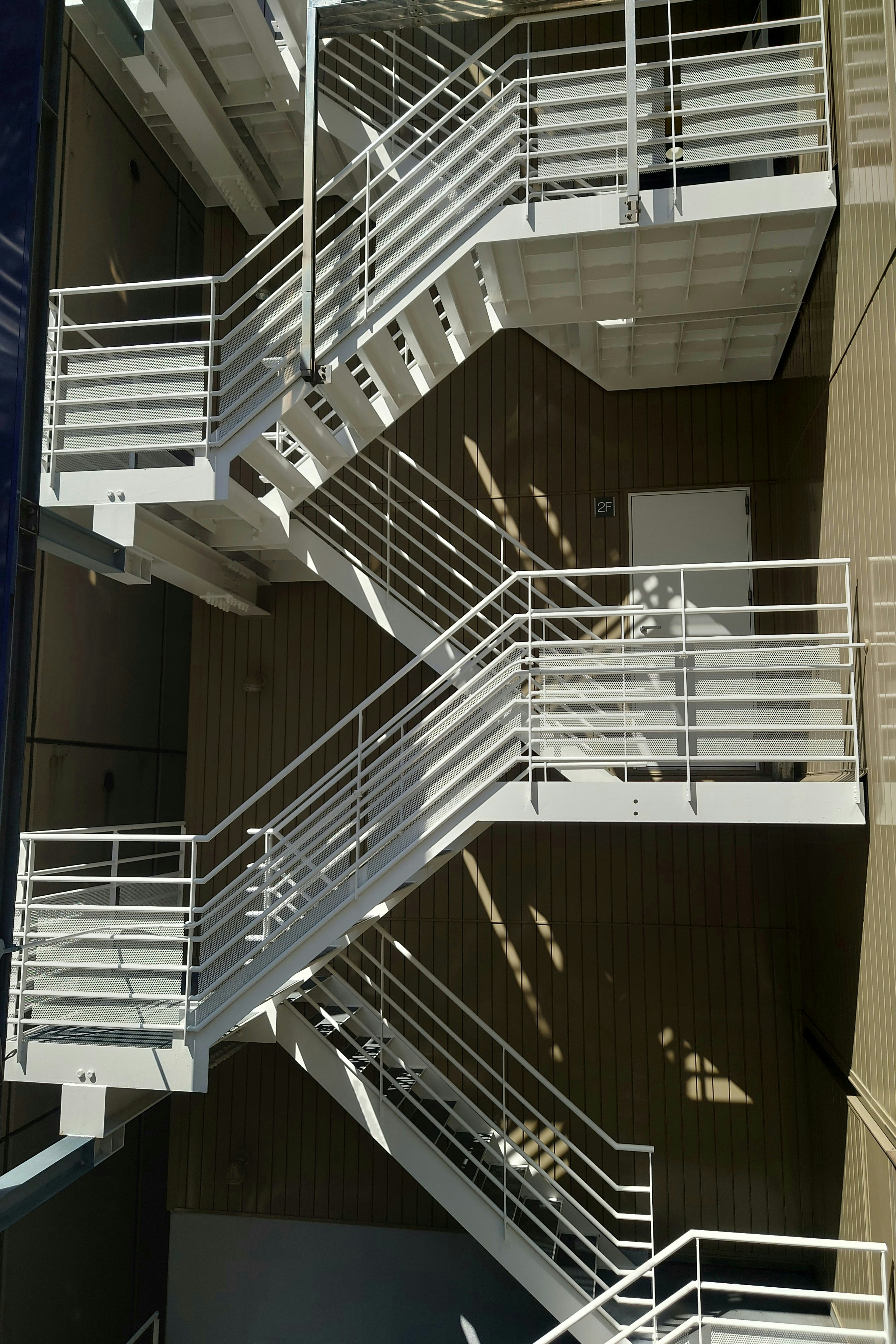 White metal fire escape stairs on the side of a building