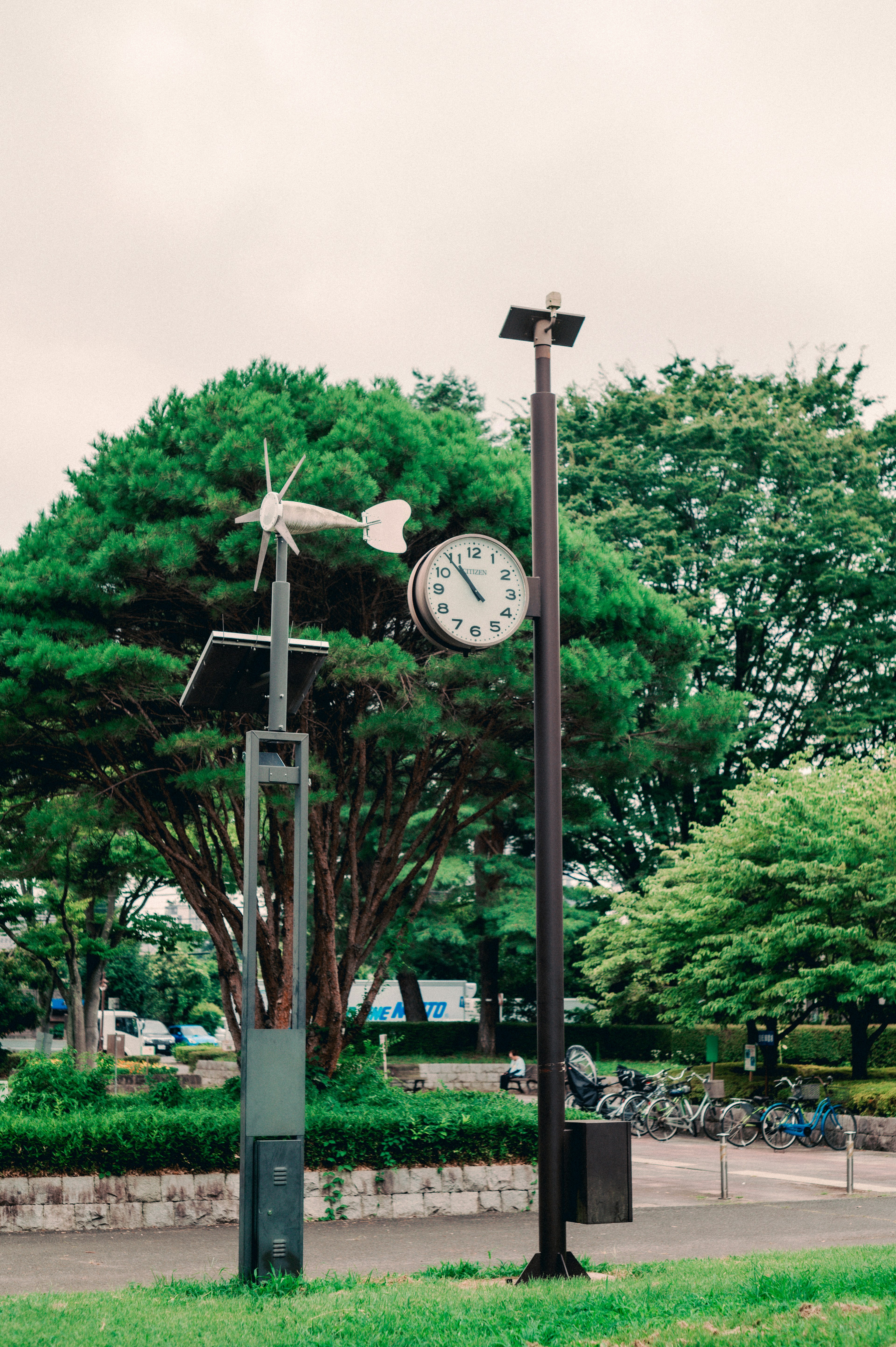 A park scene featuring a clock and an anemometer