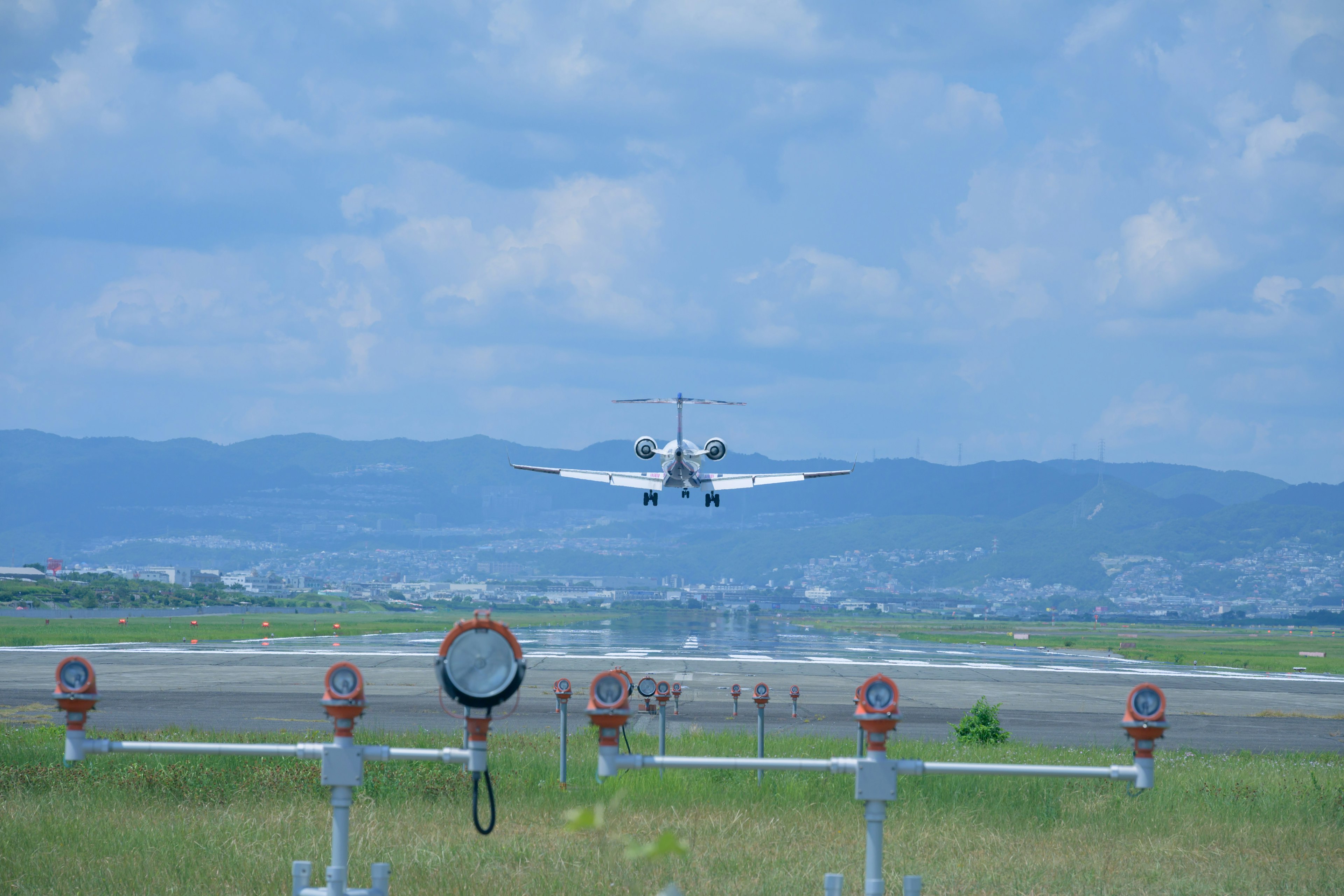 Aereo leggero in atterraggio sulla pista con paesaggio circostante